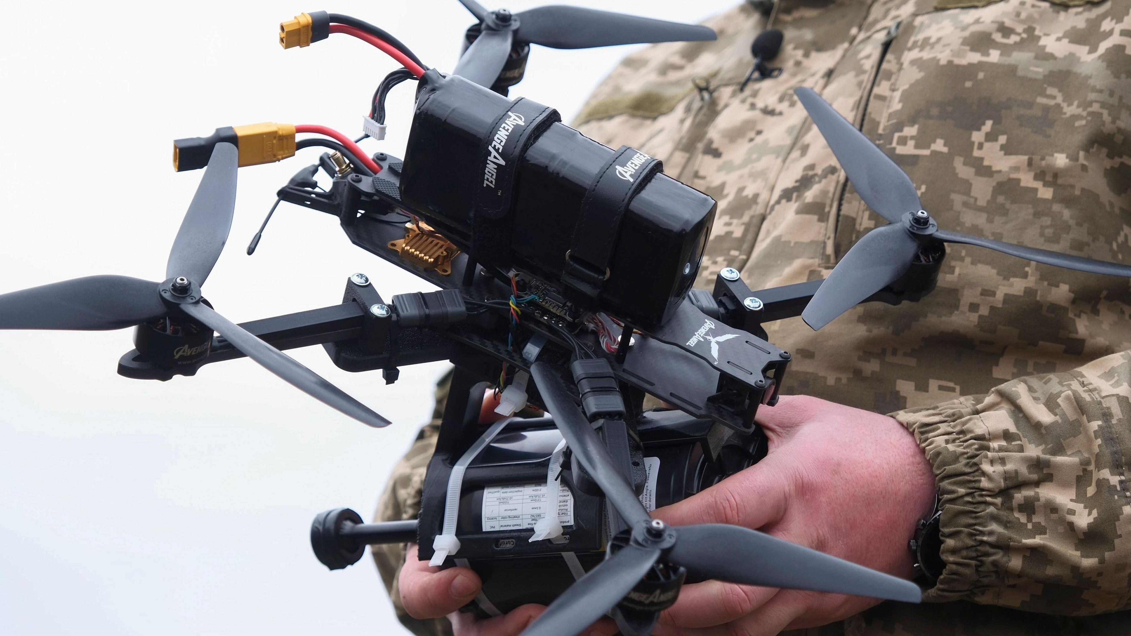 A Ukrainian soldier holding a drone