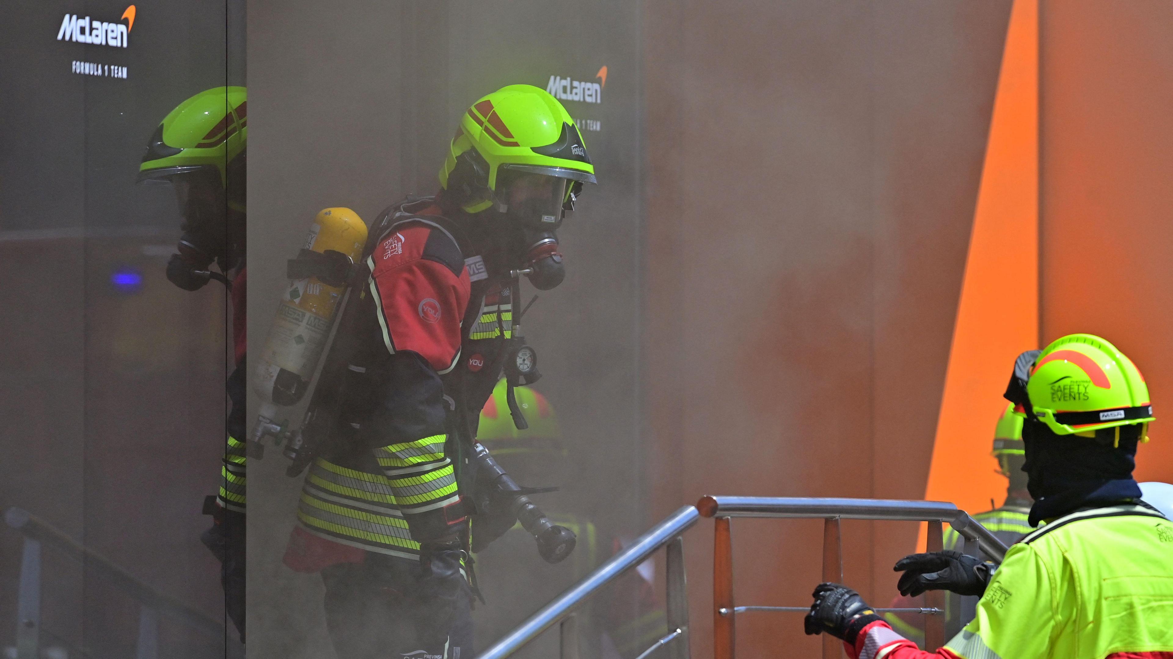 Firefighters deal with the incident in the McLaren hospitality area