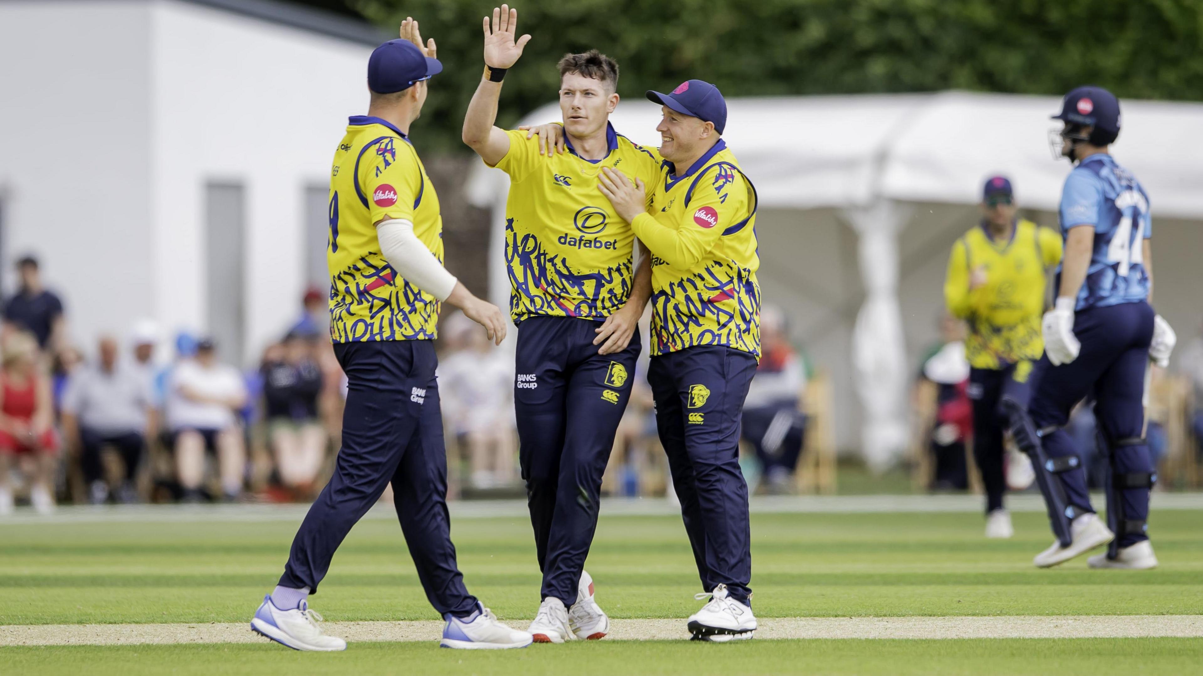 Durham's Matthew Potts is congratulated by teammates after taking a wicket against Yorkshire