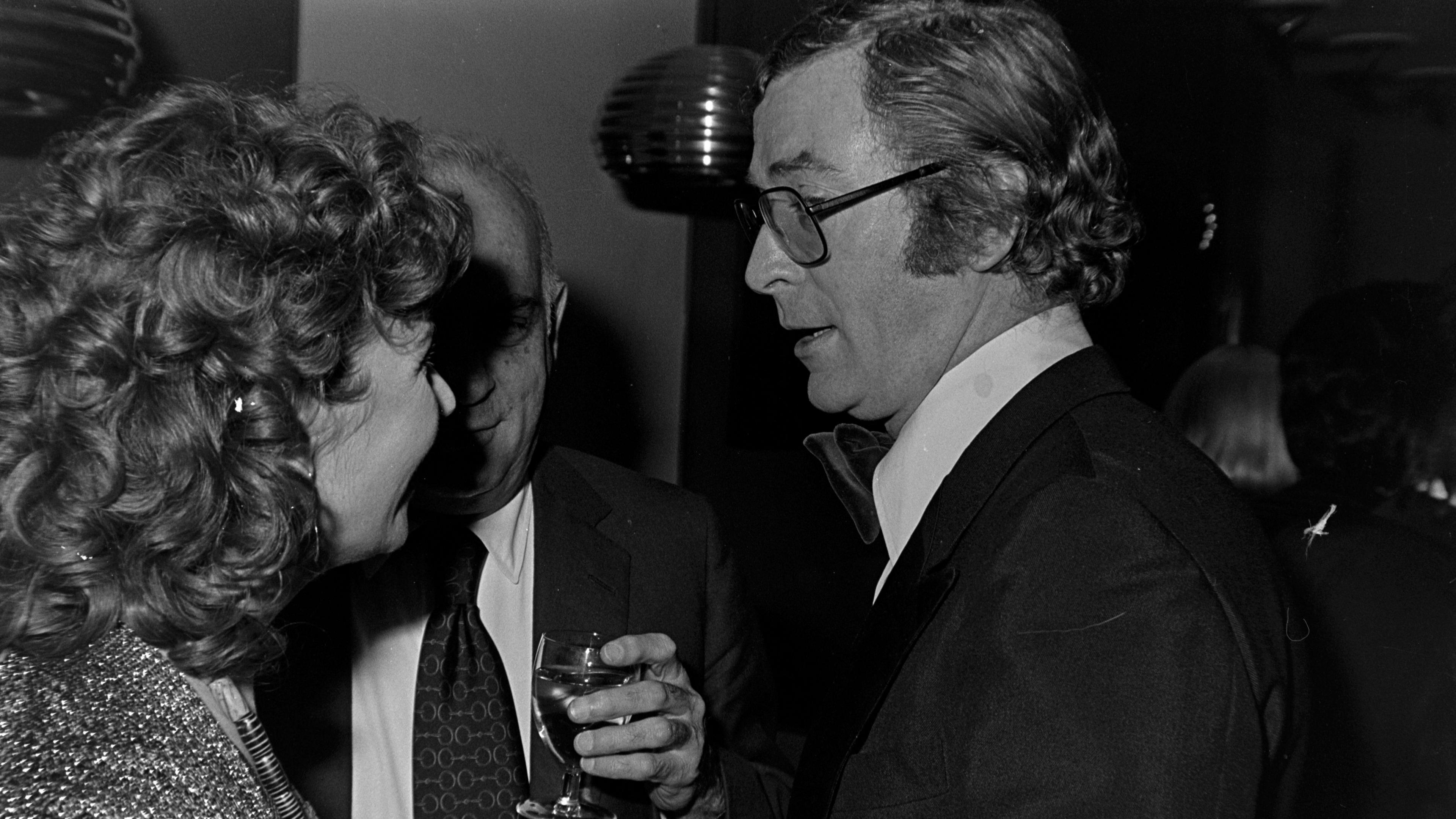 O'Brien talking to Michael Caine at Shirley MacLaine's engagement at the Palladium, on January 20, 1976