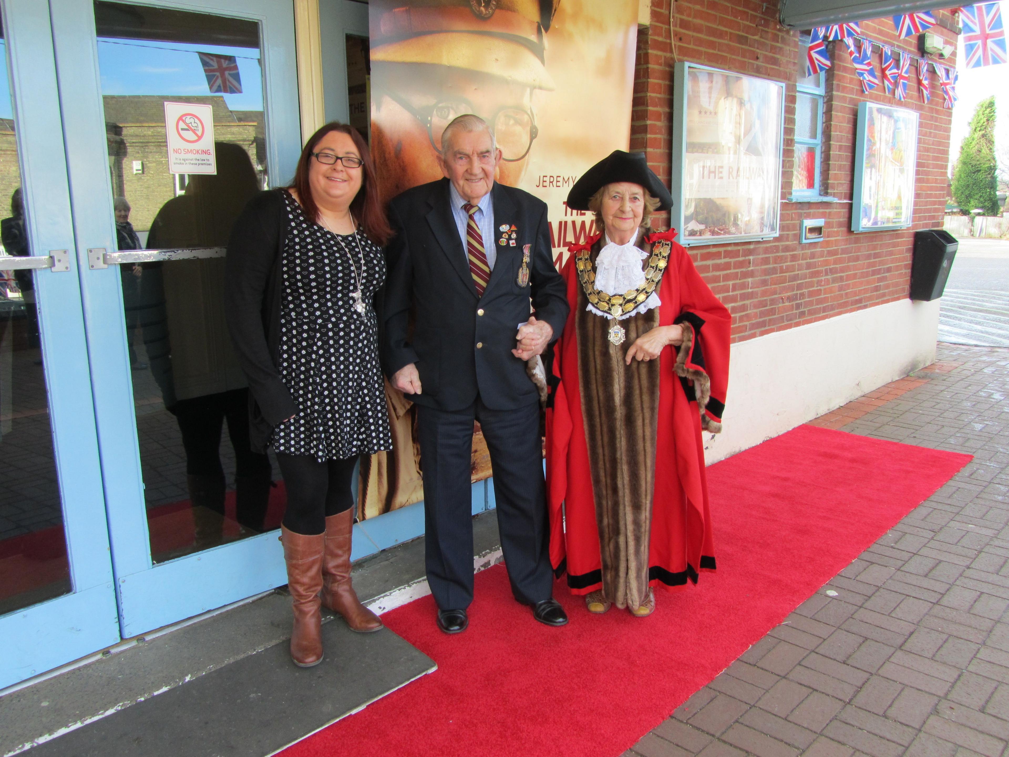 Three people standing outside the Regal Cinema entrance in Stowmarket.