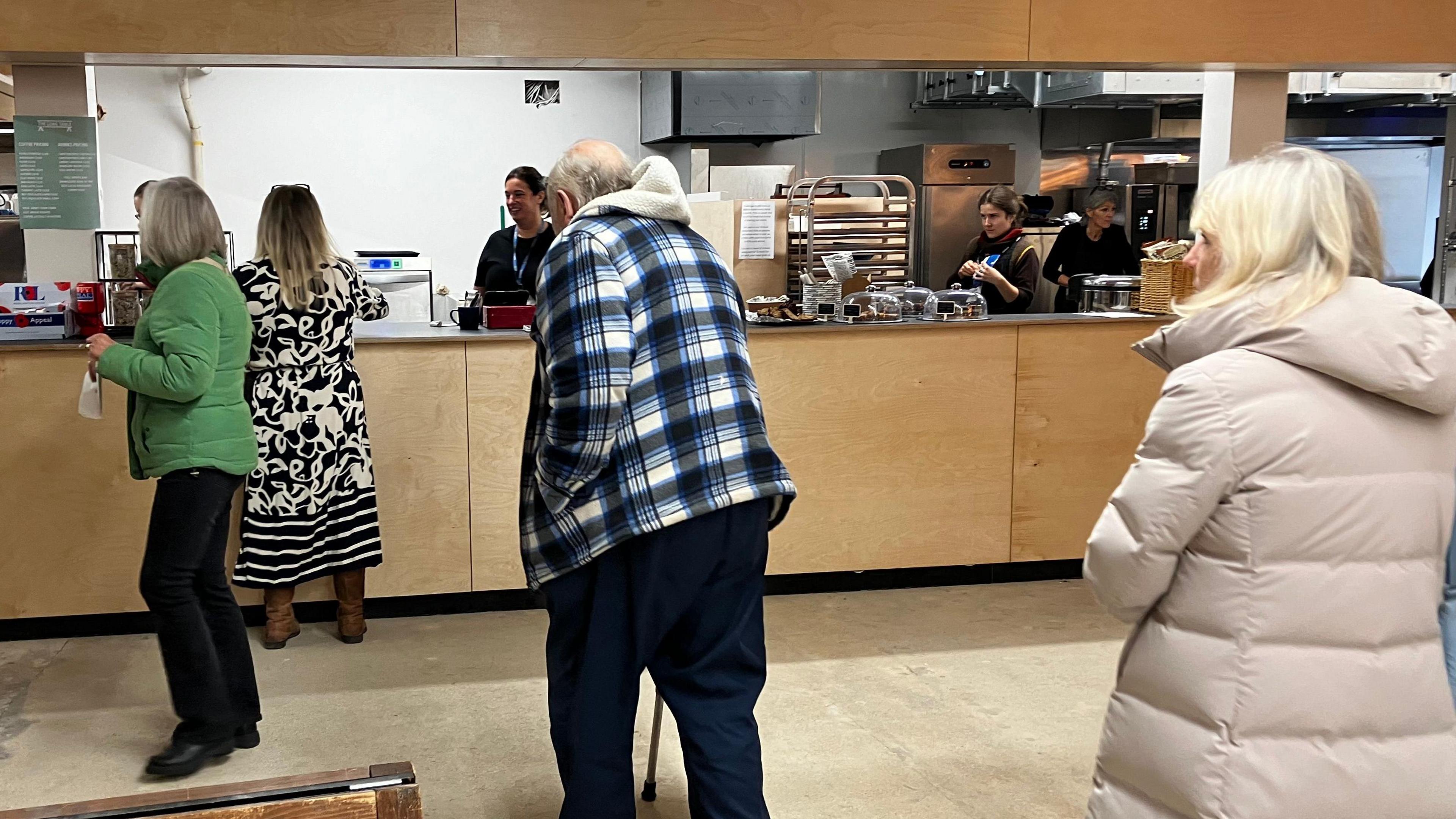 People queueing at a food counter to make an order