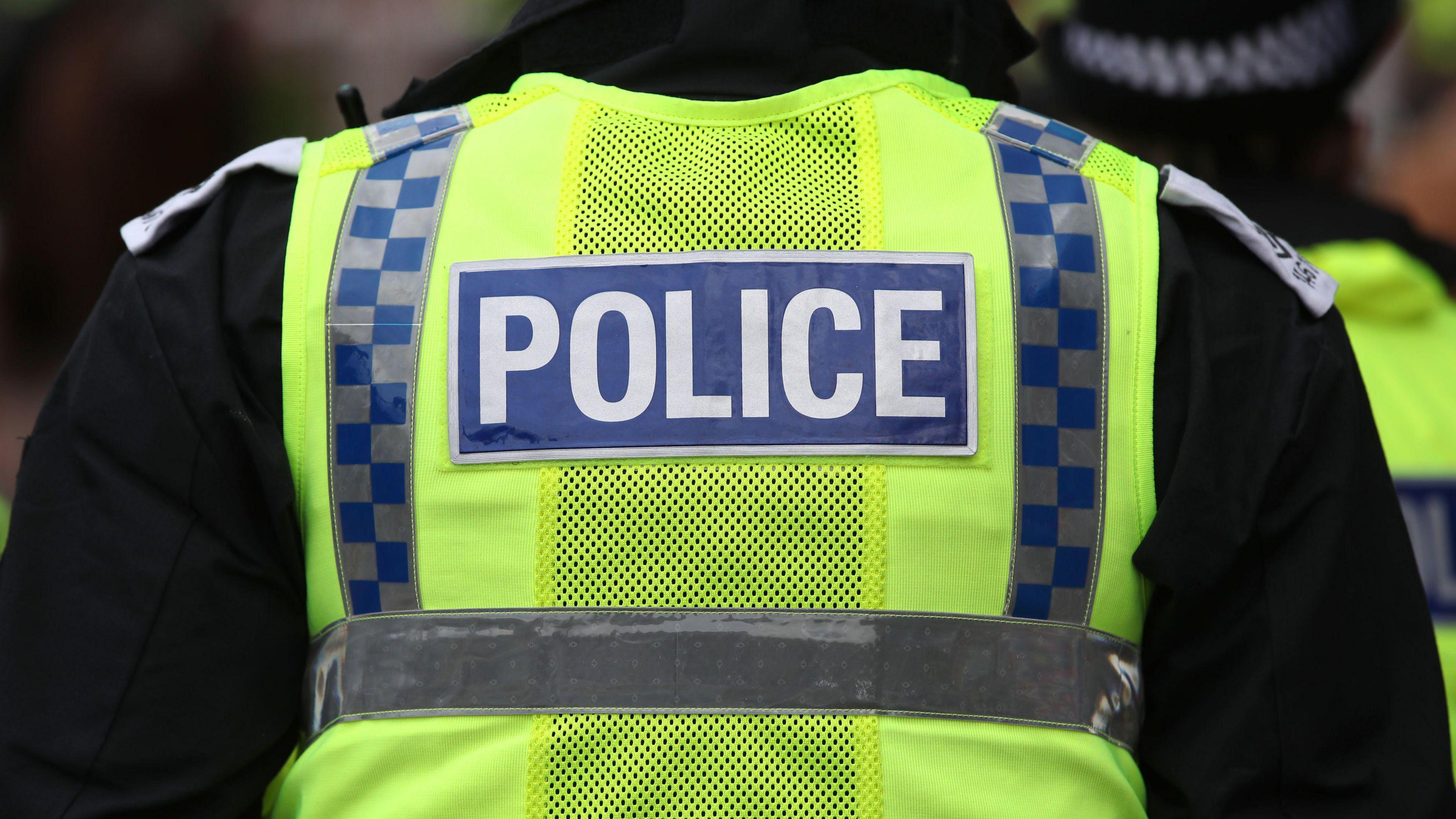 The back of a police jacket that reads POLICE in block capitals.