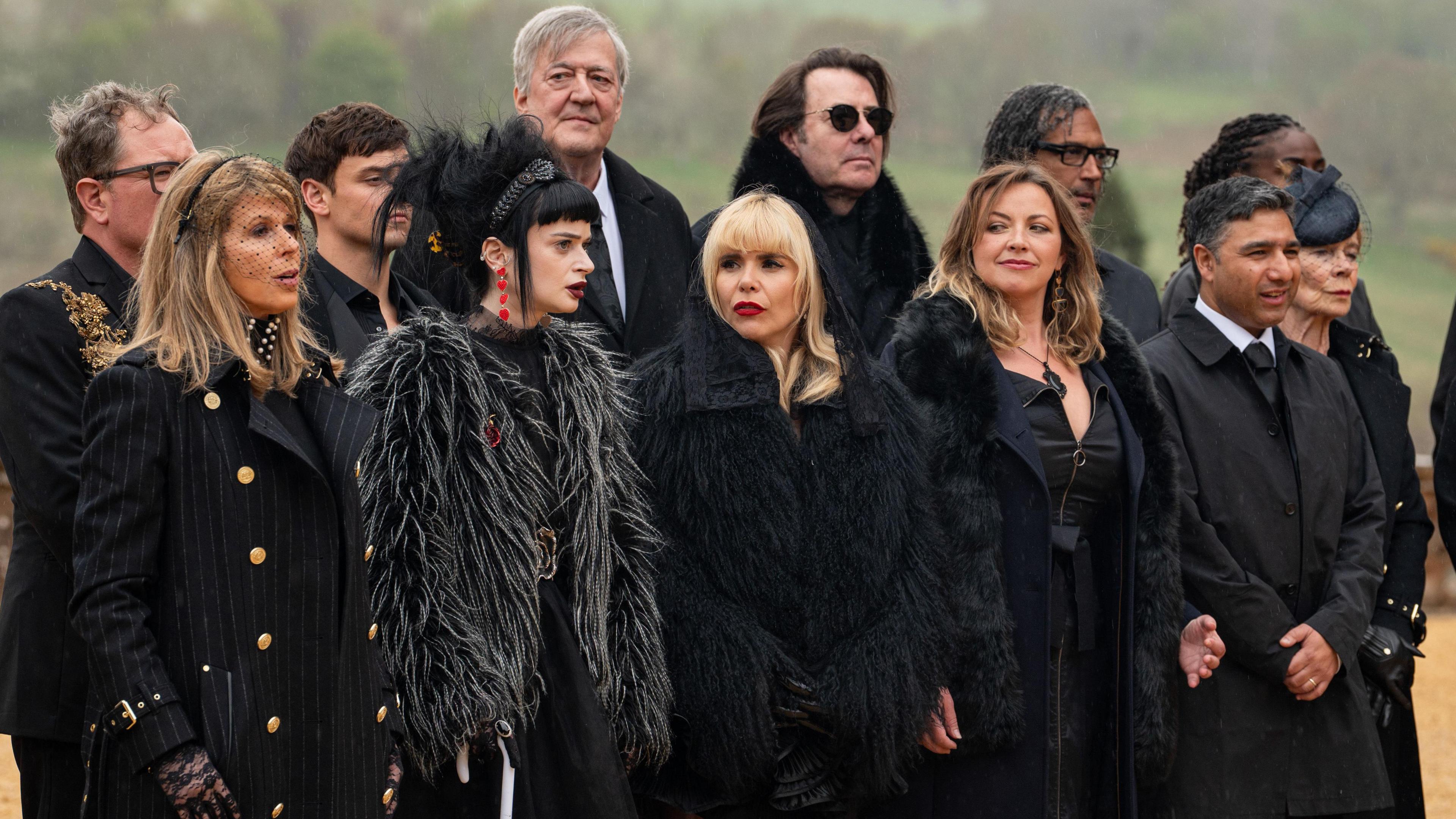 The cast of Celebrity Traitors dressed in black for a funeral scene