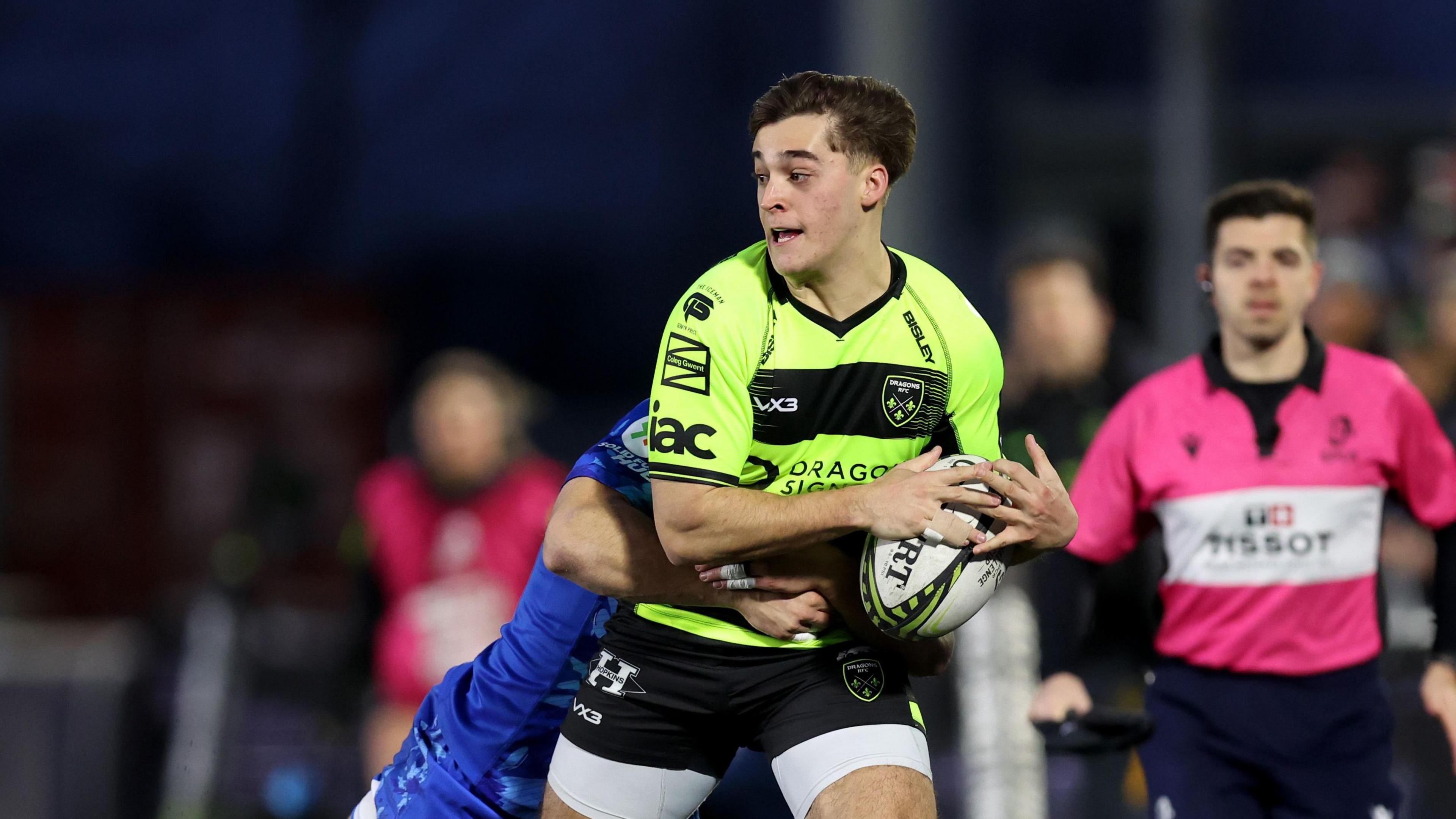 Dragons full-back Huw Anderson with the ball while being tackled by a Newcastle Falcons player  