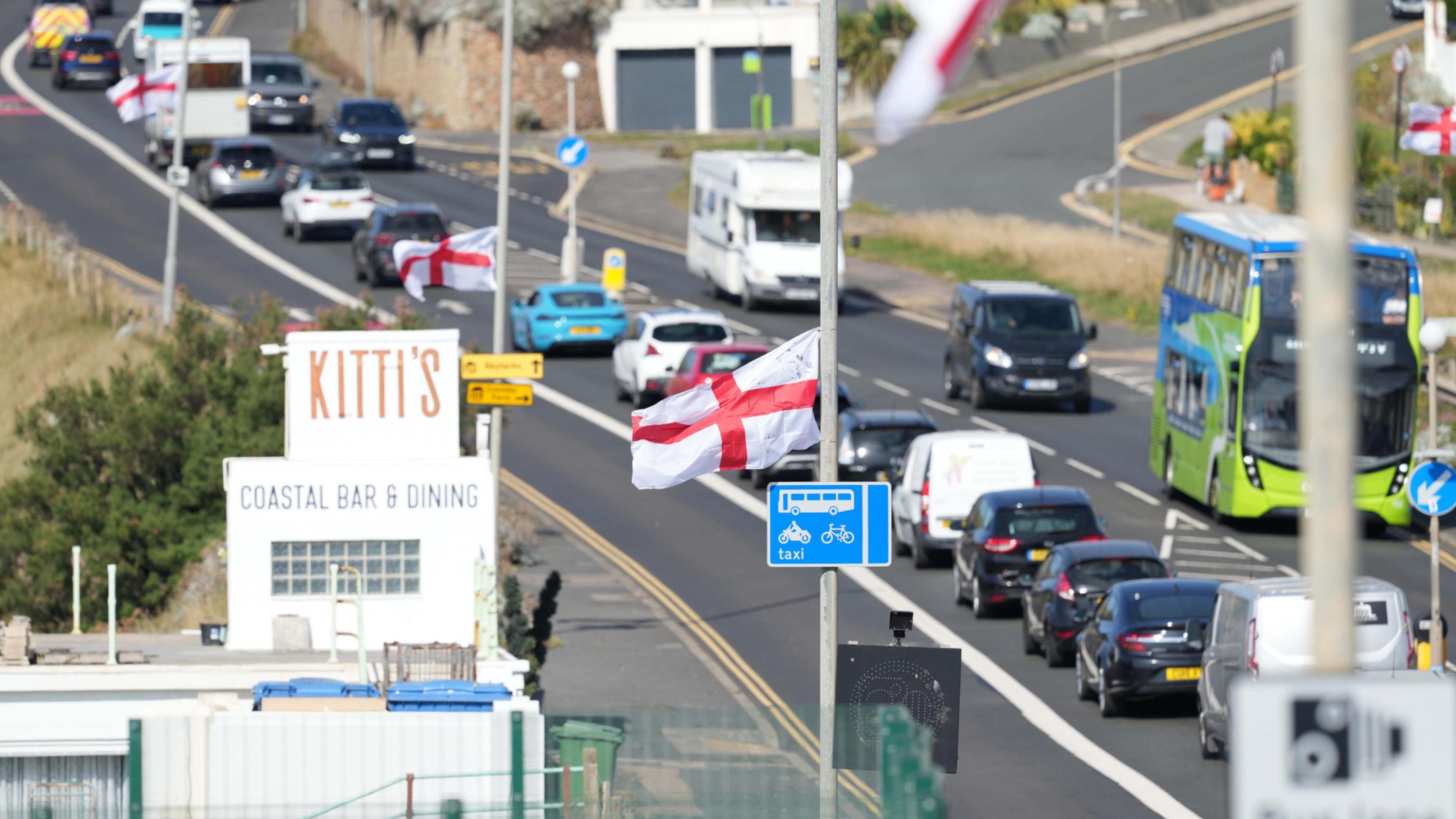 Several St George's flags fly from lampposts beside the A259 in East Sussex.