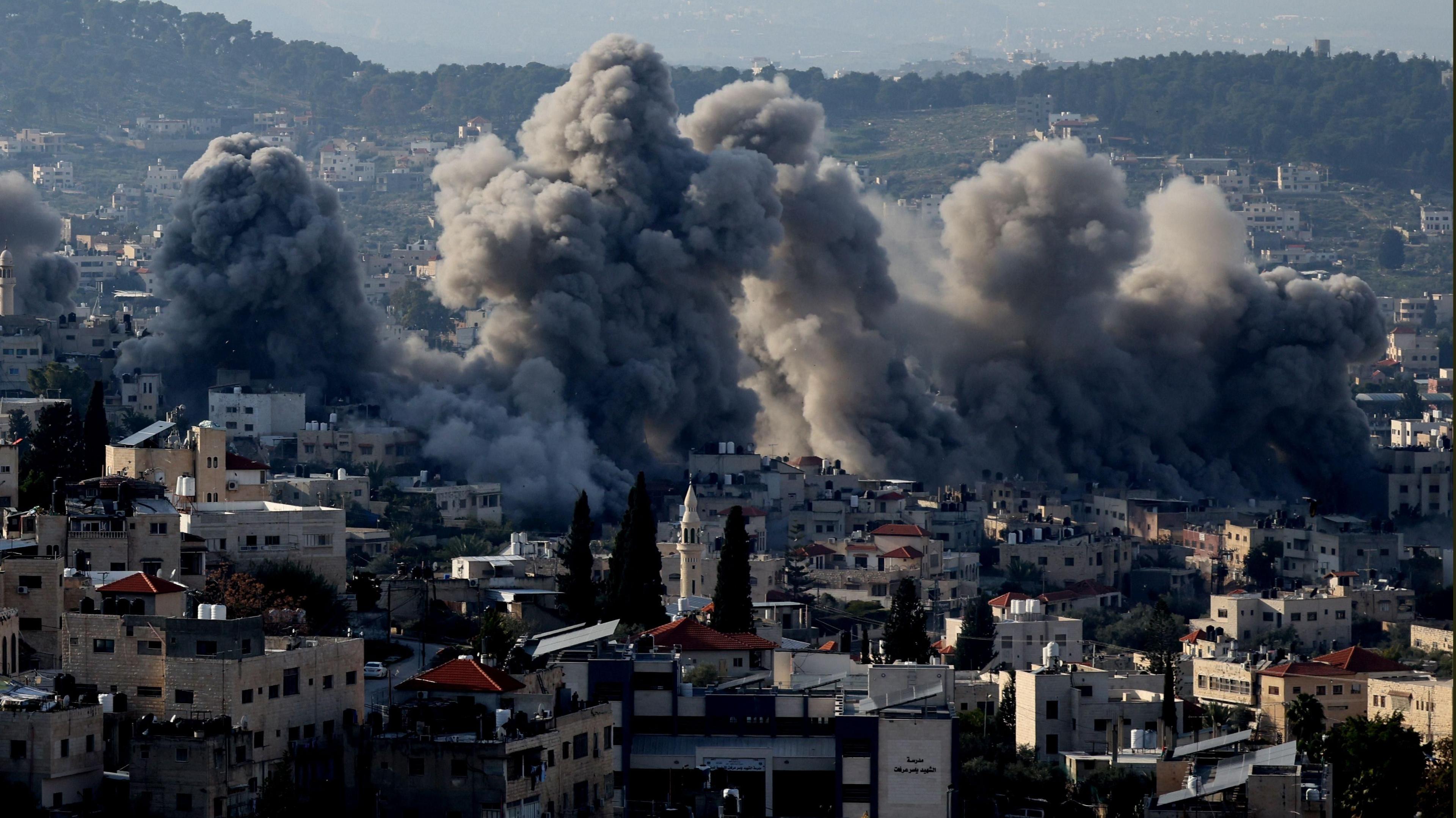 Smoke rises from Jenin refugee camp in the occupied West Bank after Israeli forces set off explosives to demolish more than 20 structures (2 February 2025)