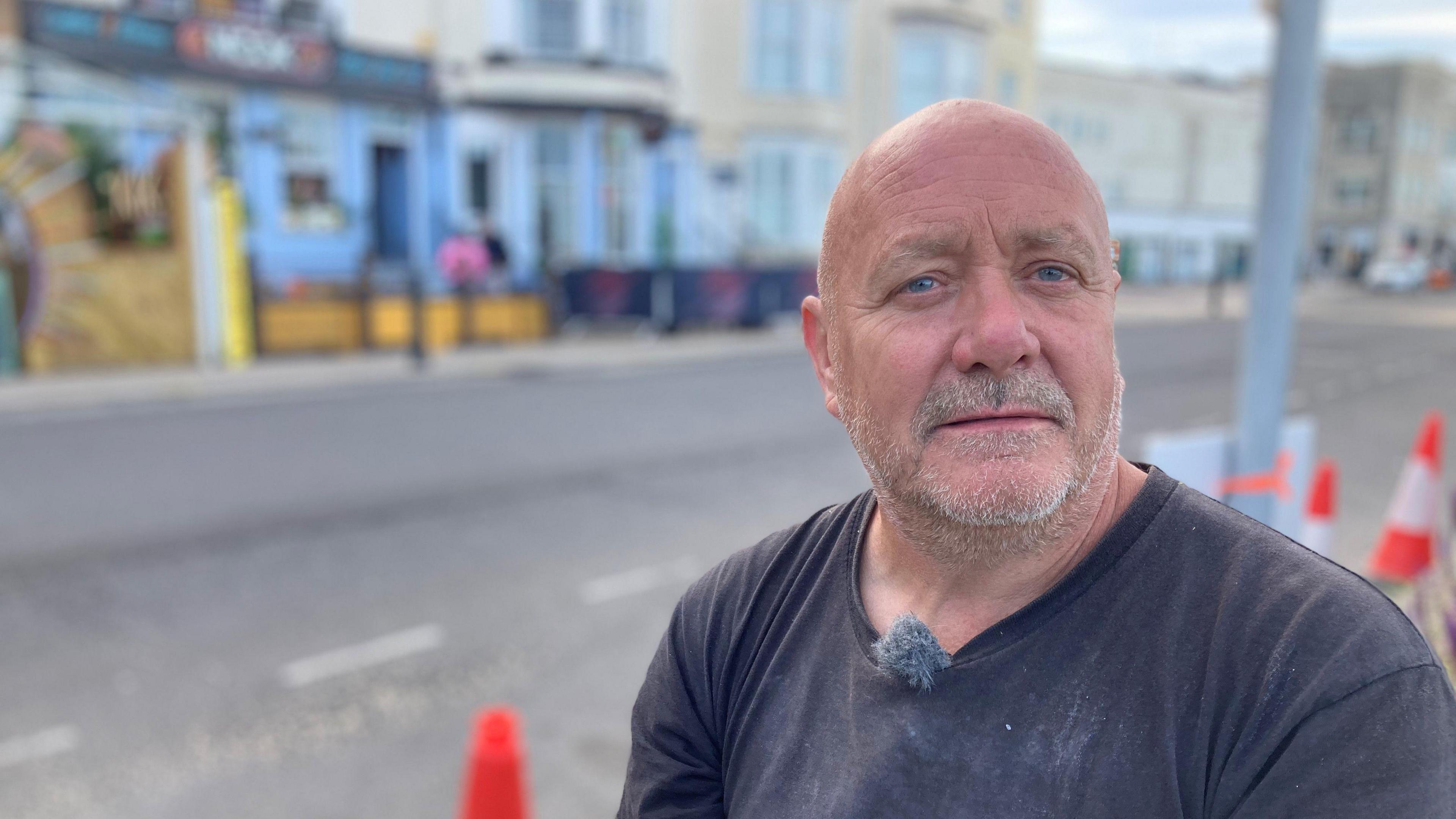 David Court stood outside the bar where the crash happened, traffic cones can be seen in the background behind him