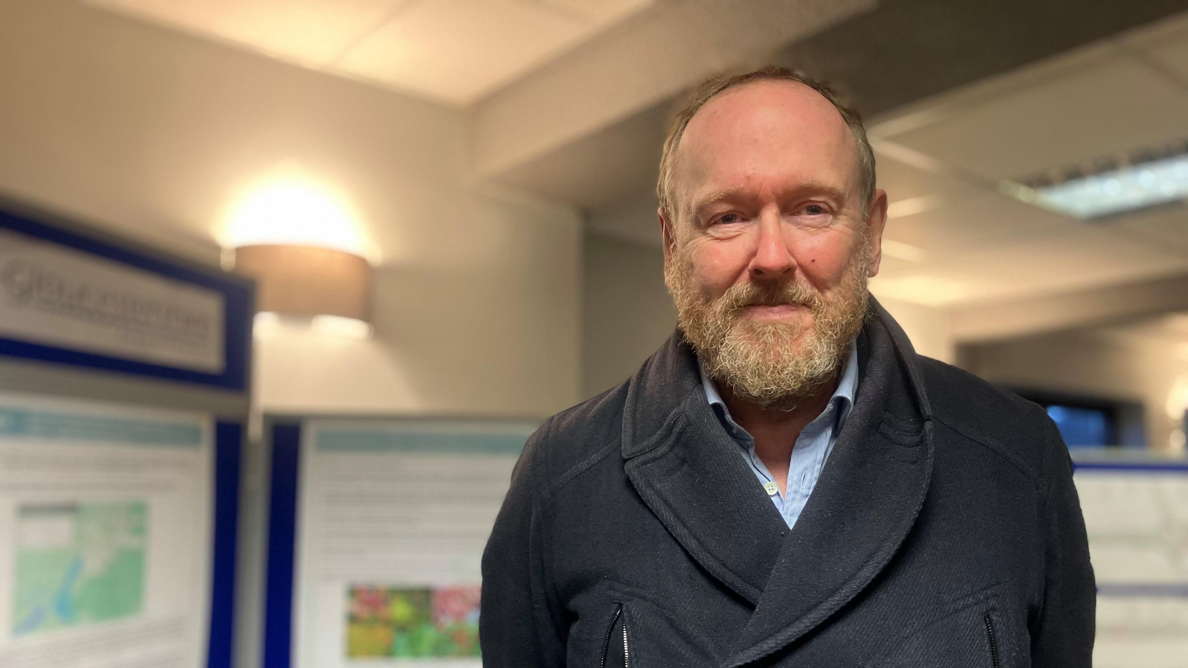 Councillor David Gray stood in front of some blurry Gloucestershire County Council background