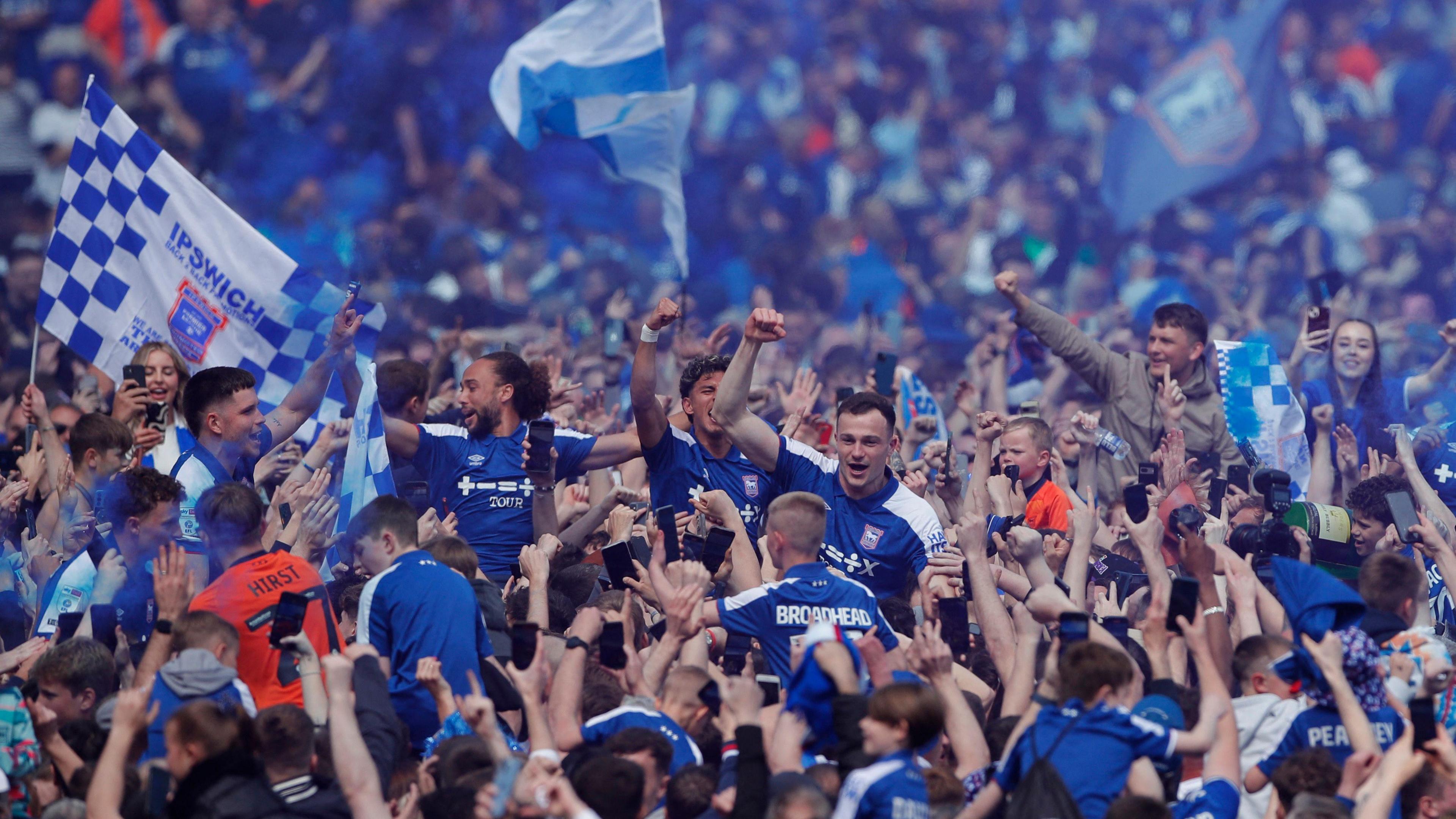 Ipswich players are carried by the crowd following promotion to the Premier League