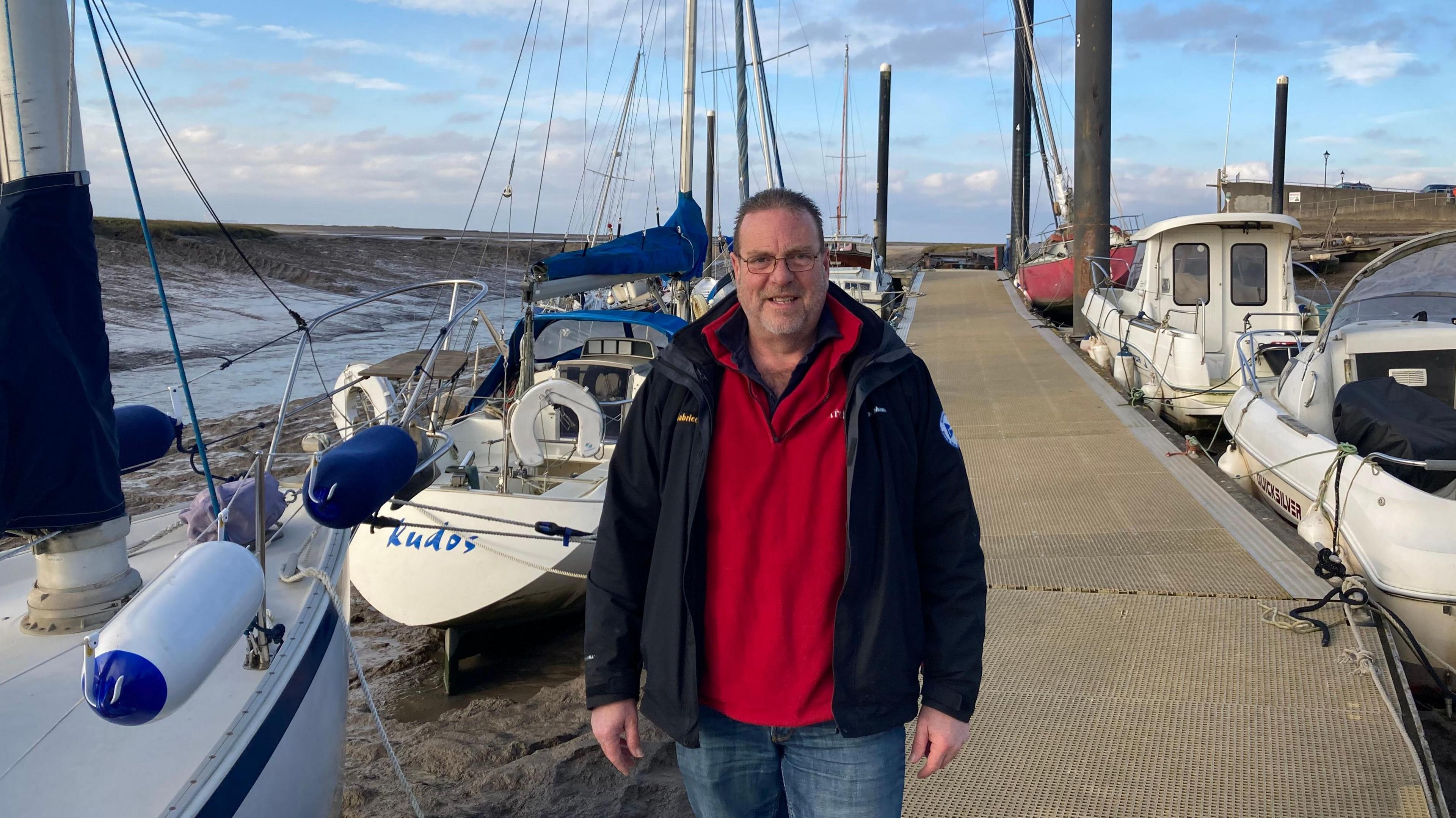 Michael Clarke stood in front of sailing boats  