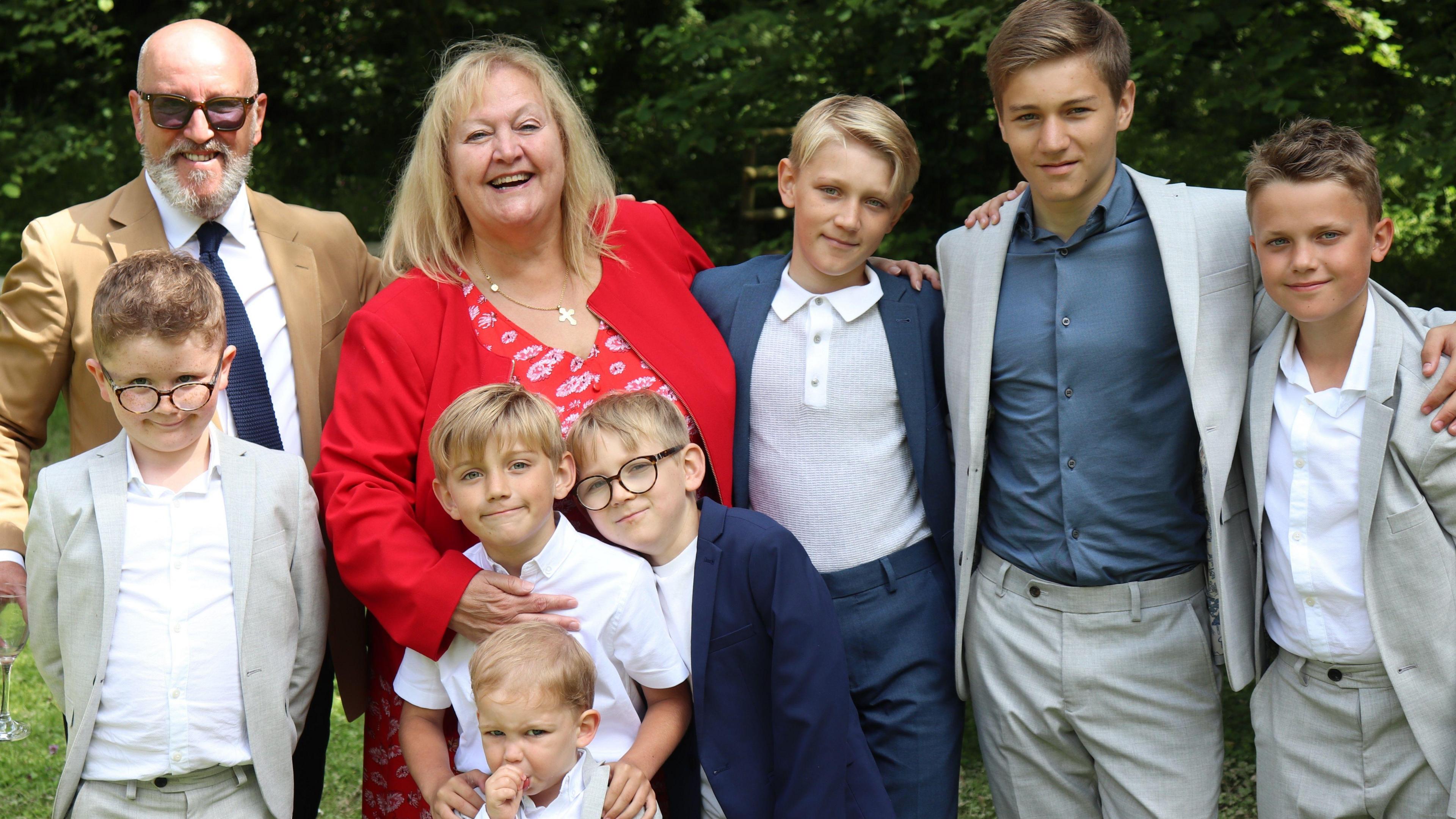 Dame Julie and her husband Iain Hall to the left of the picture, surrounded by her grandchildren in formal attire.