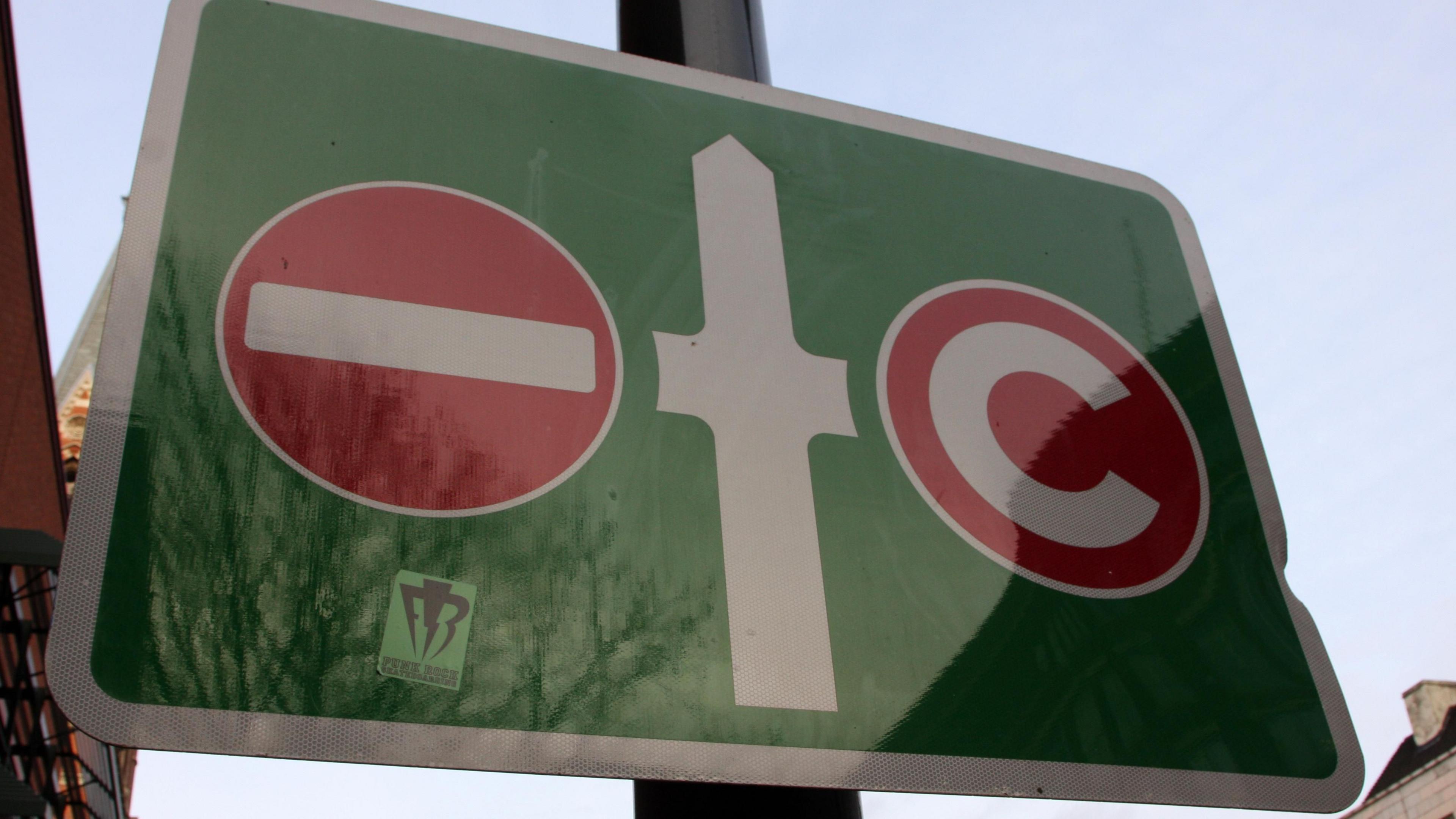 A sign shows no entry for drivers going left and a congestion charge for those going right