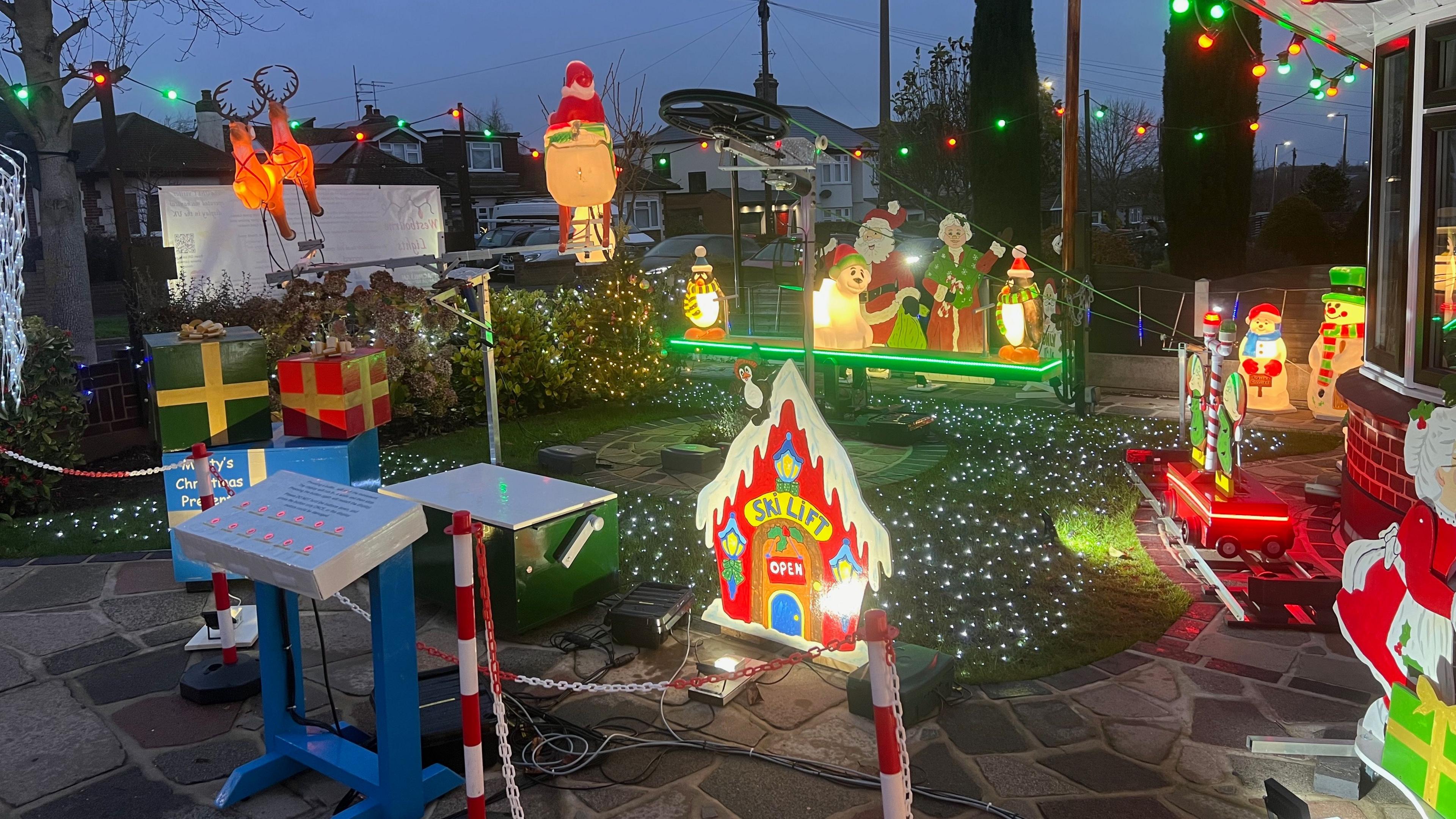 Several lit-up Christmas decorations in a front garden.