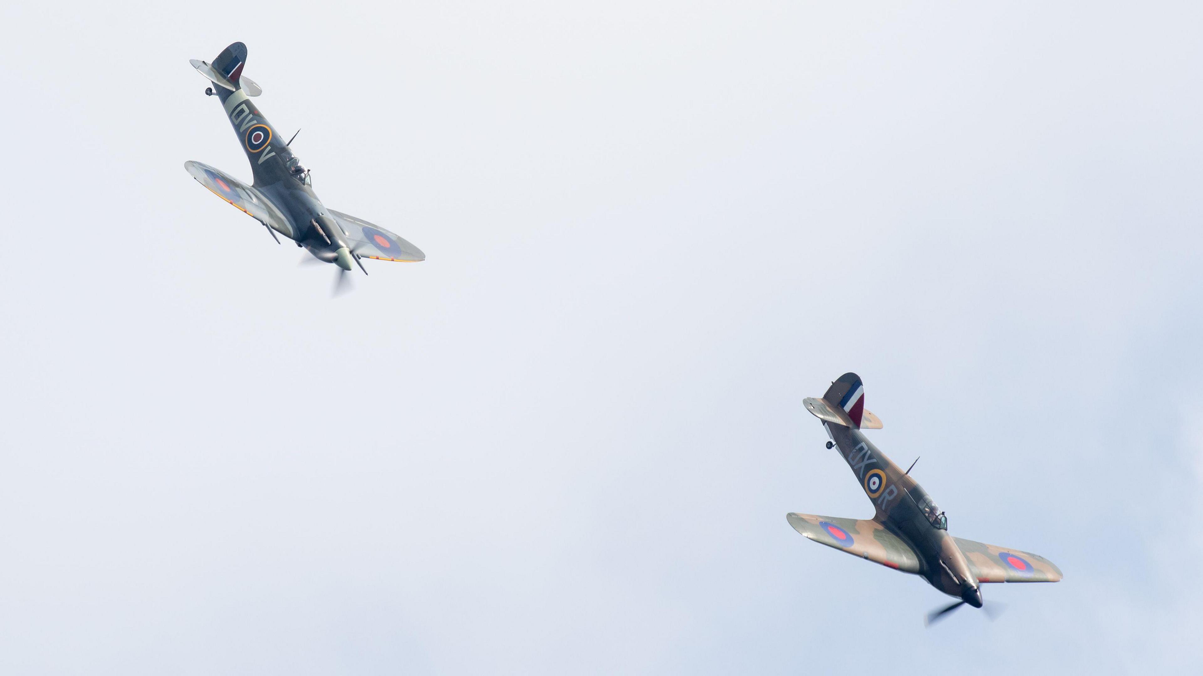 Two Spitfire aircraft flying nose down in formation