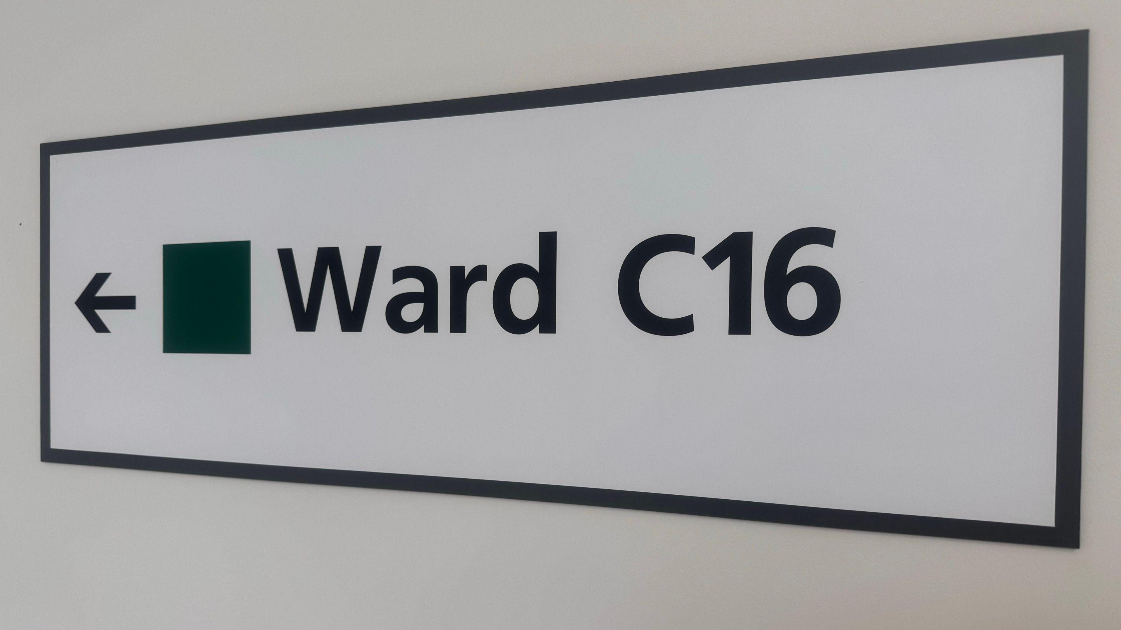 A white rectangle sign with "Ward C16" written on it in black