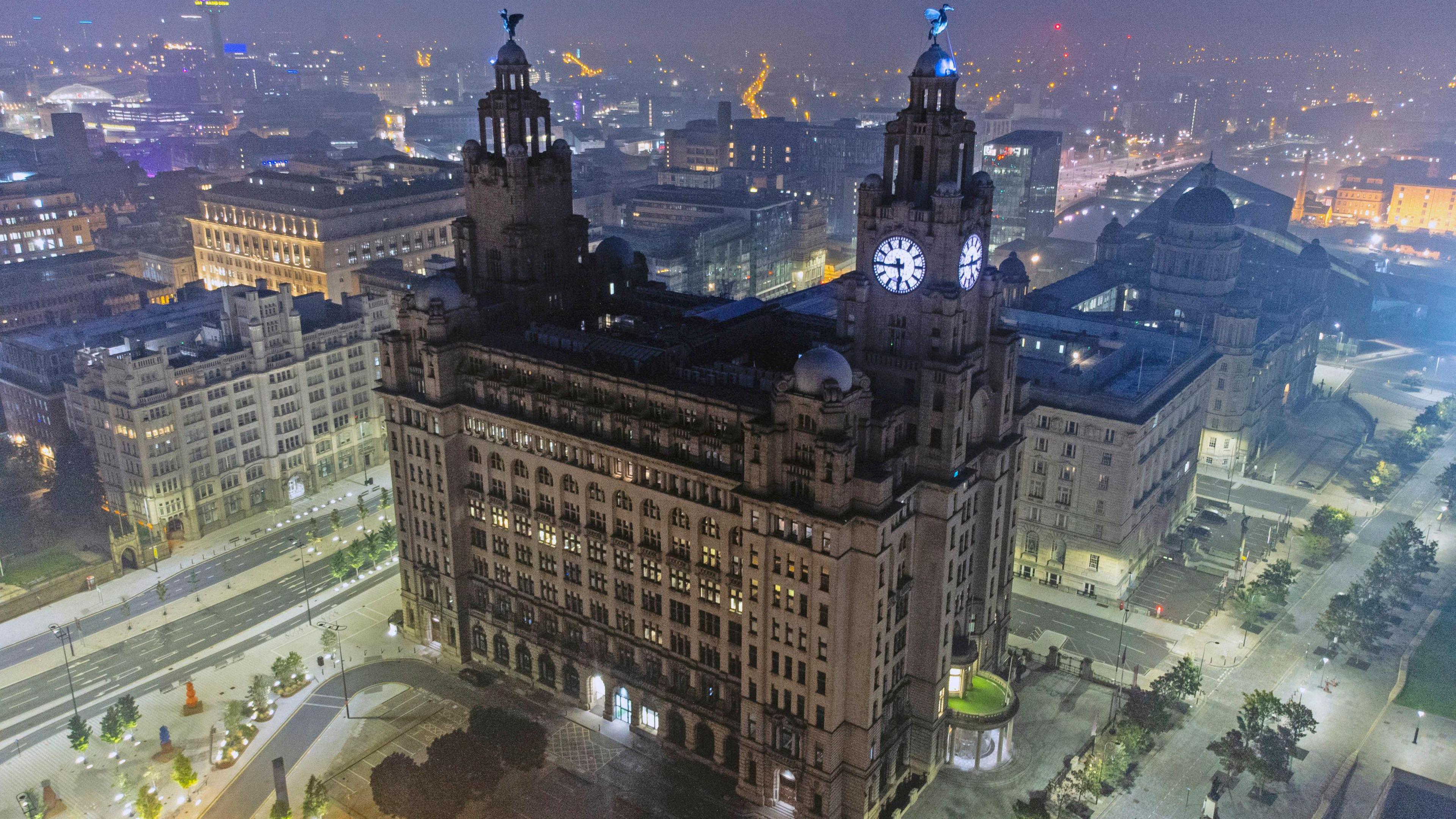 Aerial shot of the Liver Building at night with the Liver Birds on towers at either side of the building.