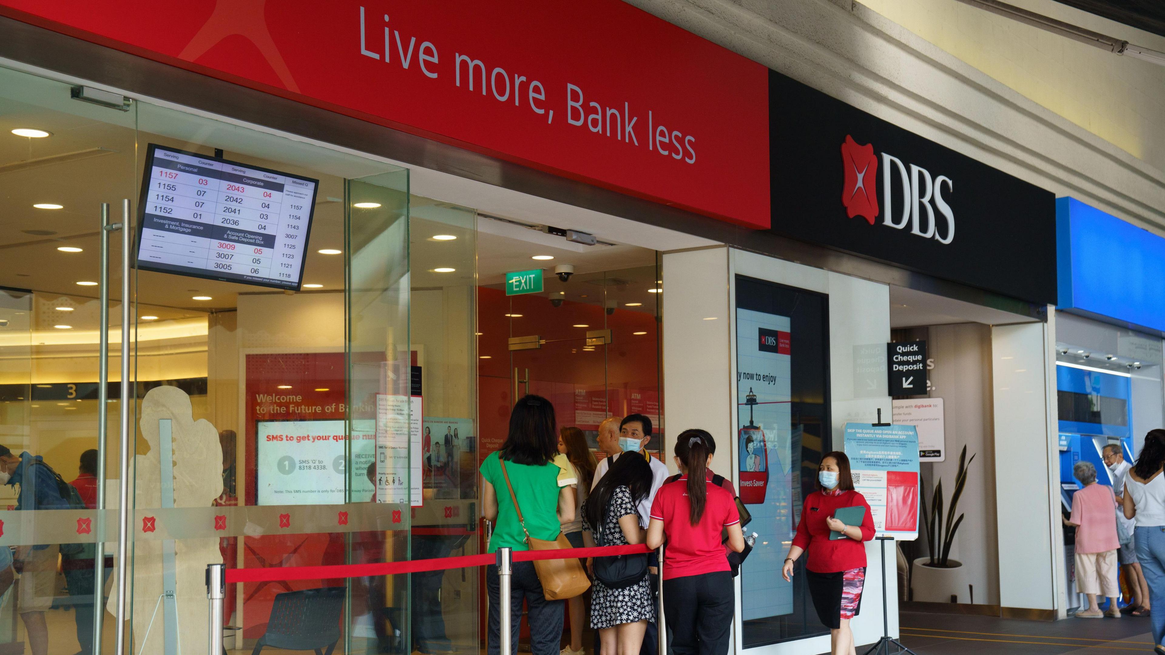 Customers and bank staff outside a DBS branch in Singapore, on 5 August, 2024.