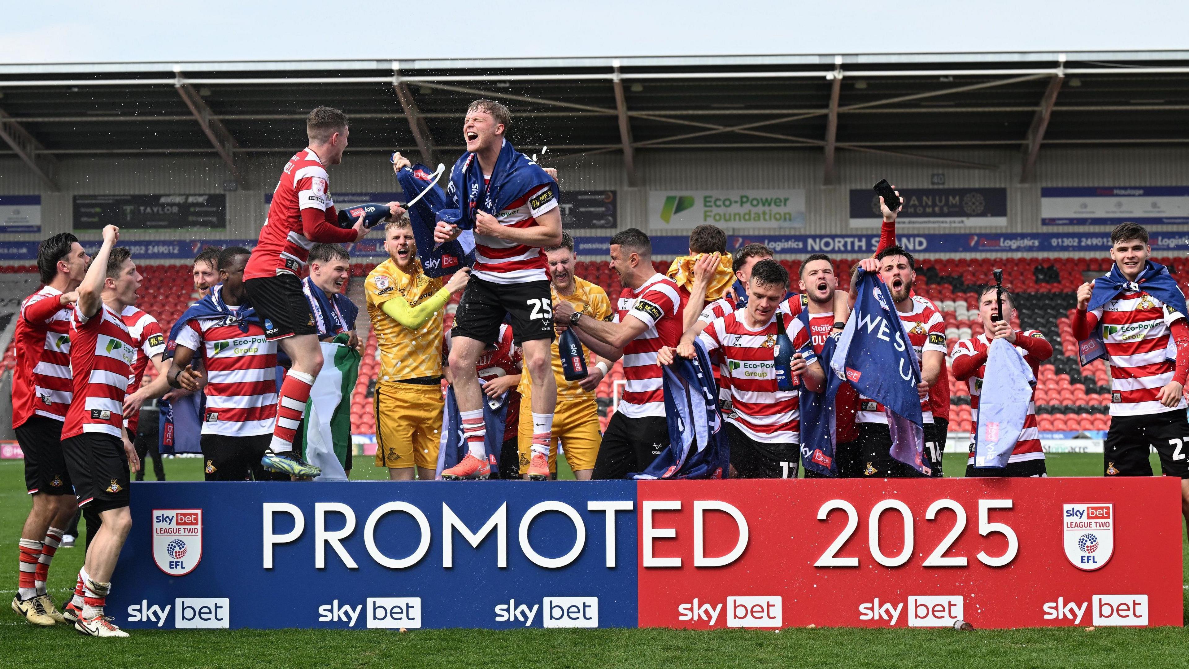 Doncaster's players celebrating winning promotion from League Two
