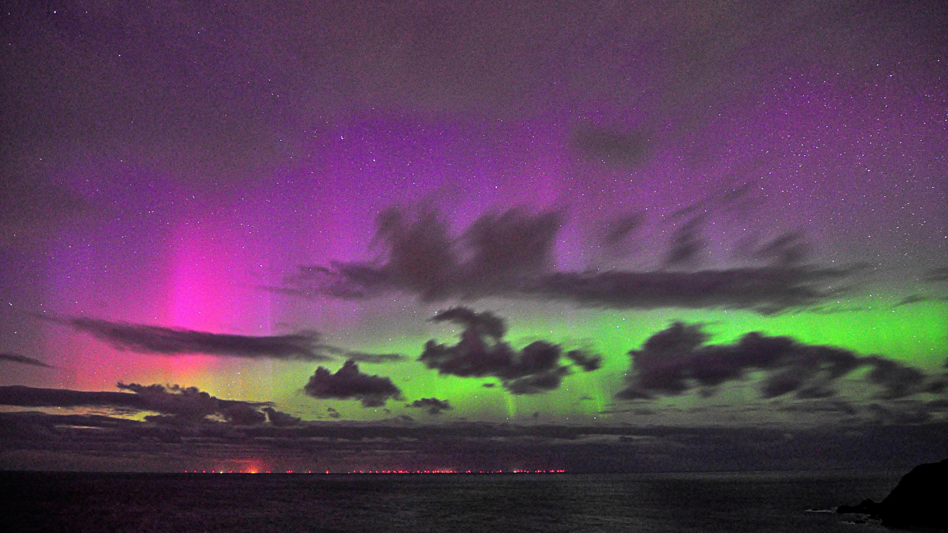 The purple, pink and green hues of the aurora borealis are clearly visible in a starry sky