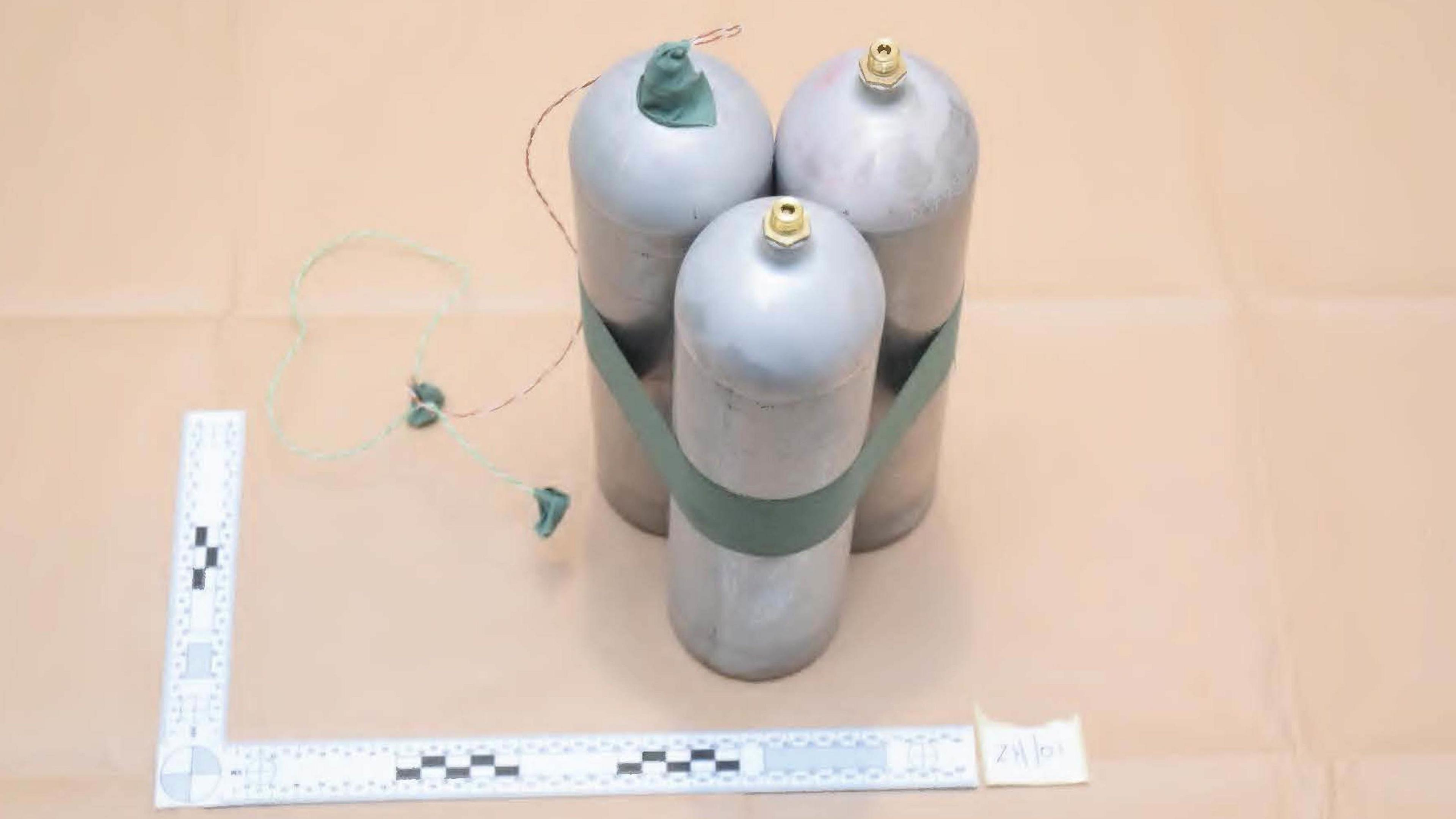 Three large silver canisters taped together with green tape are pictured in a police photo