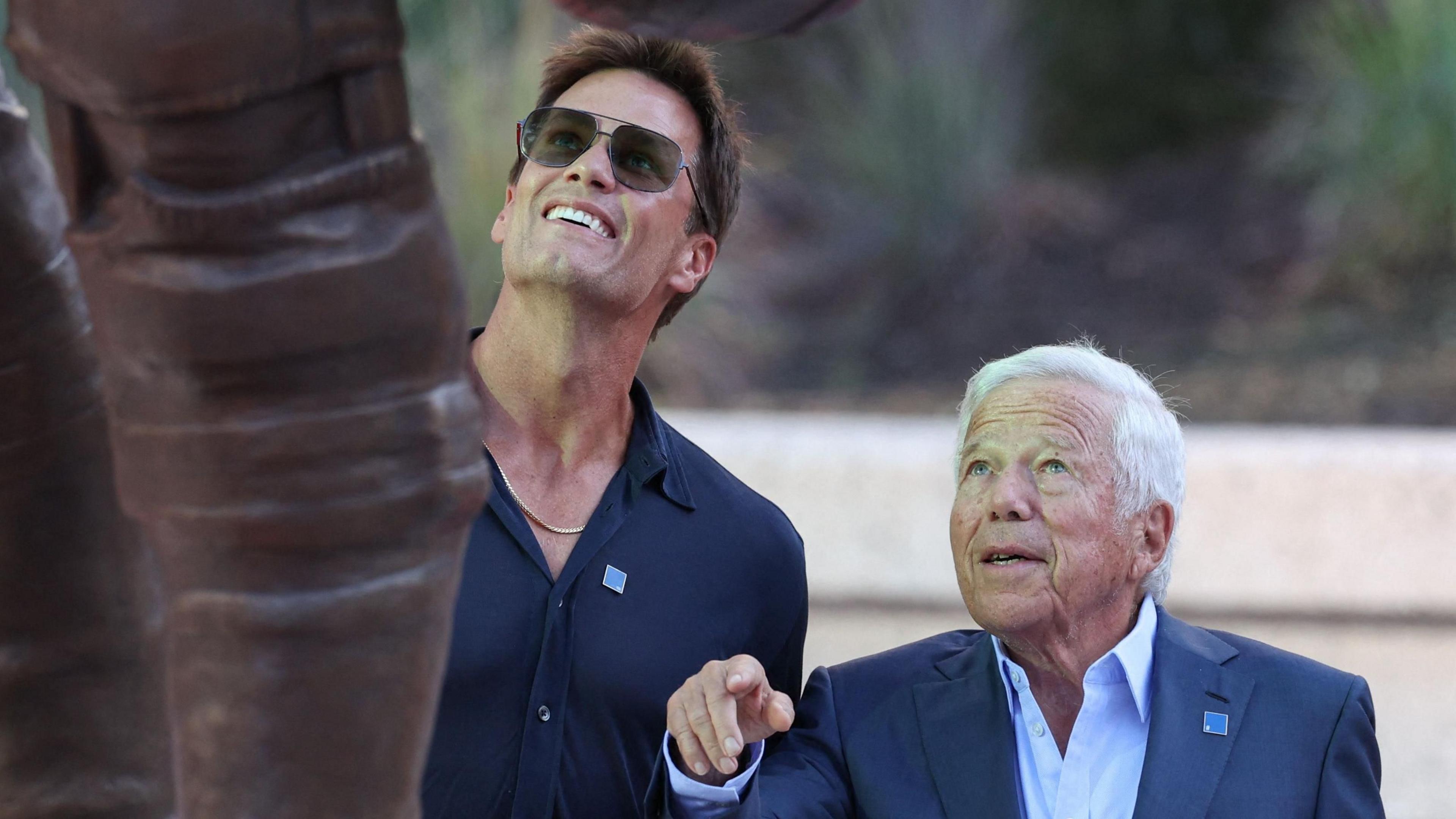 Tom Brady looks up at his statue with New England Patriots owner Robert Kraft