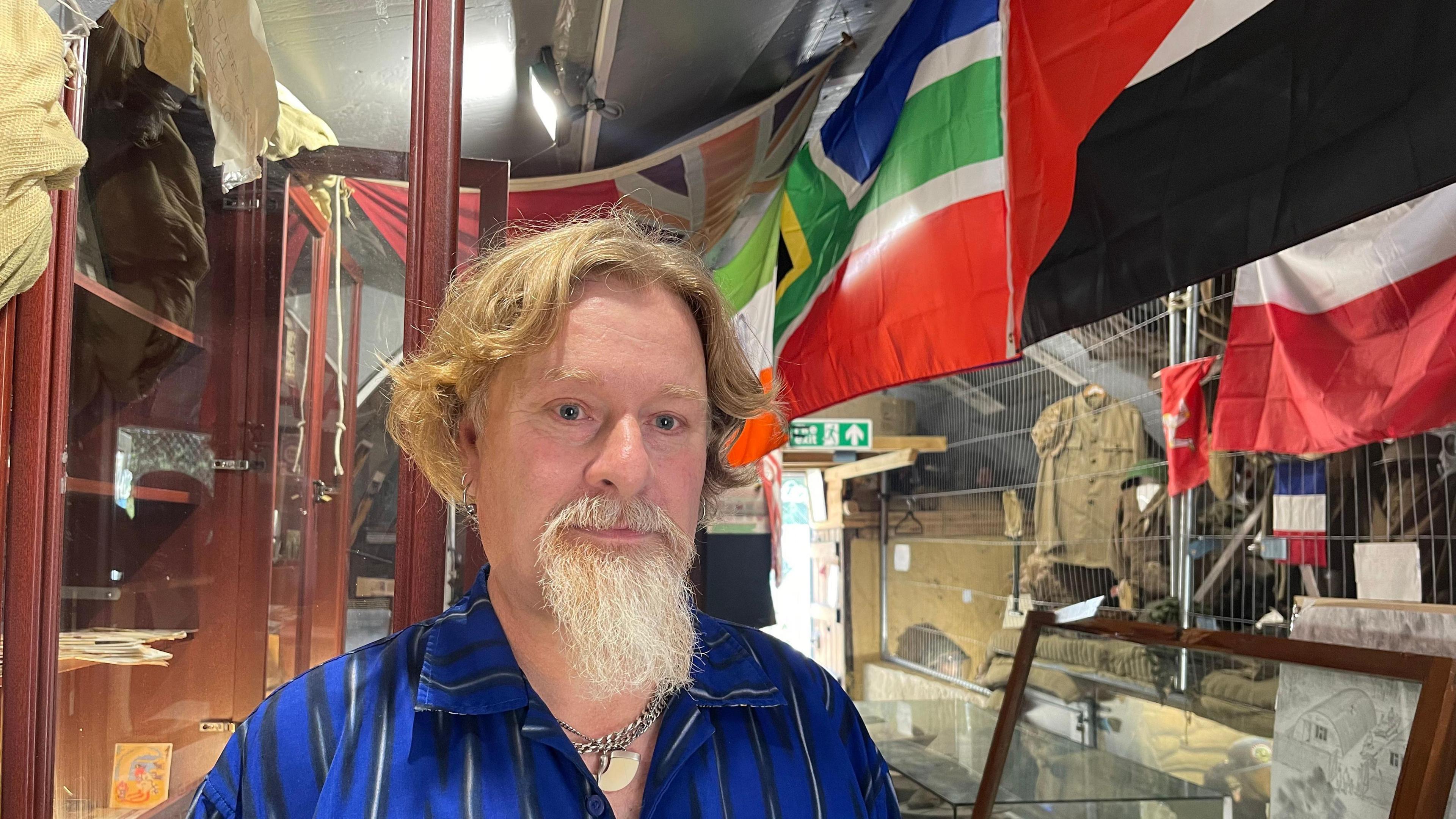 Paul Smith with flags behind him in Nissan hut museum