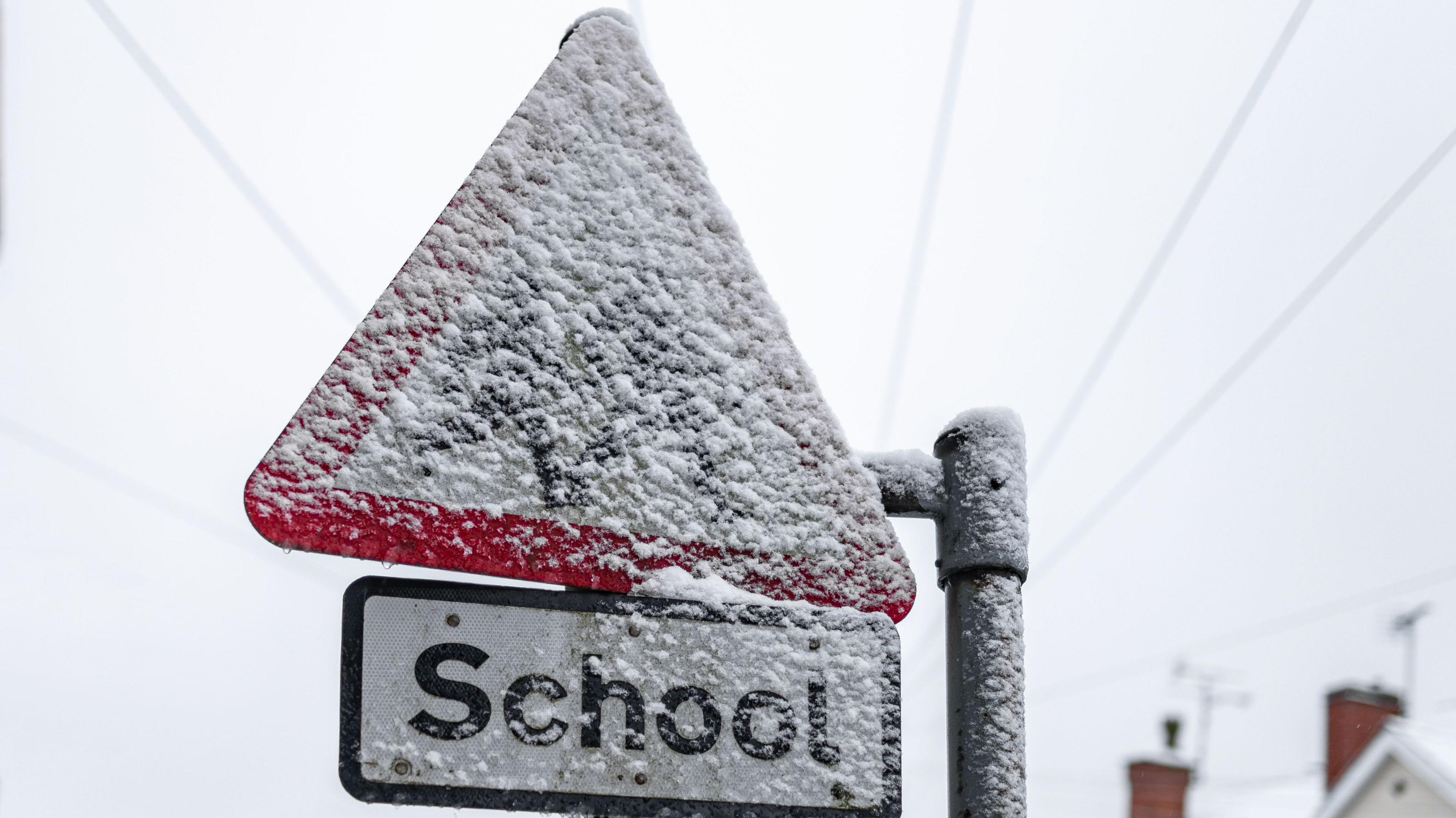 School sign covered in snow