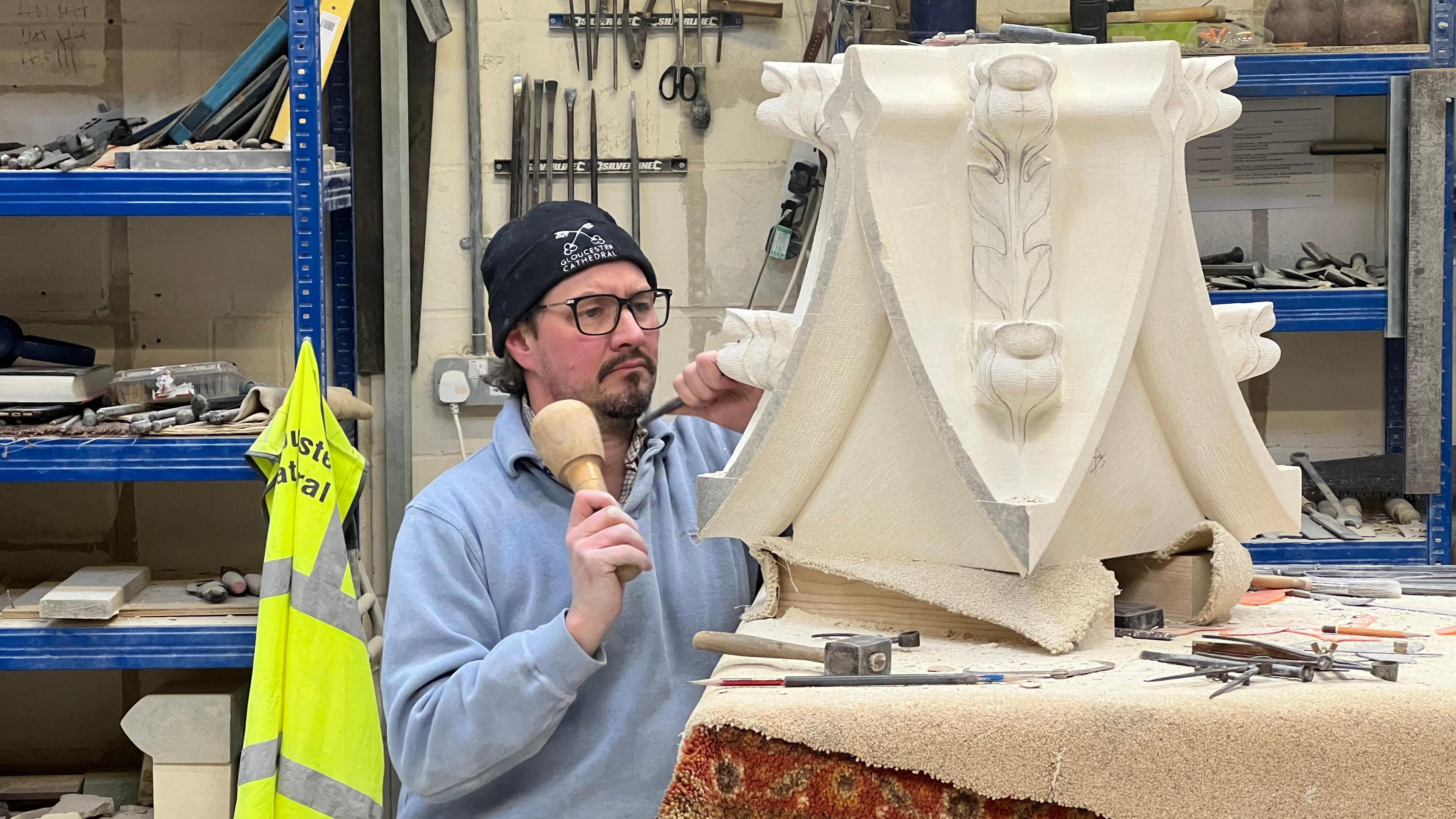 Paul Synan working on a piece of stone in Gloucester Cathedral's workshop.