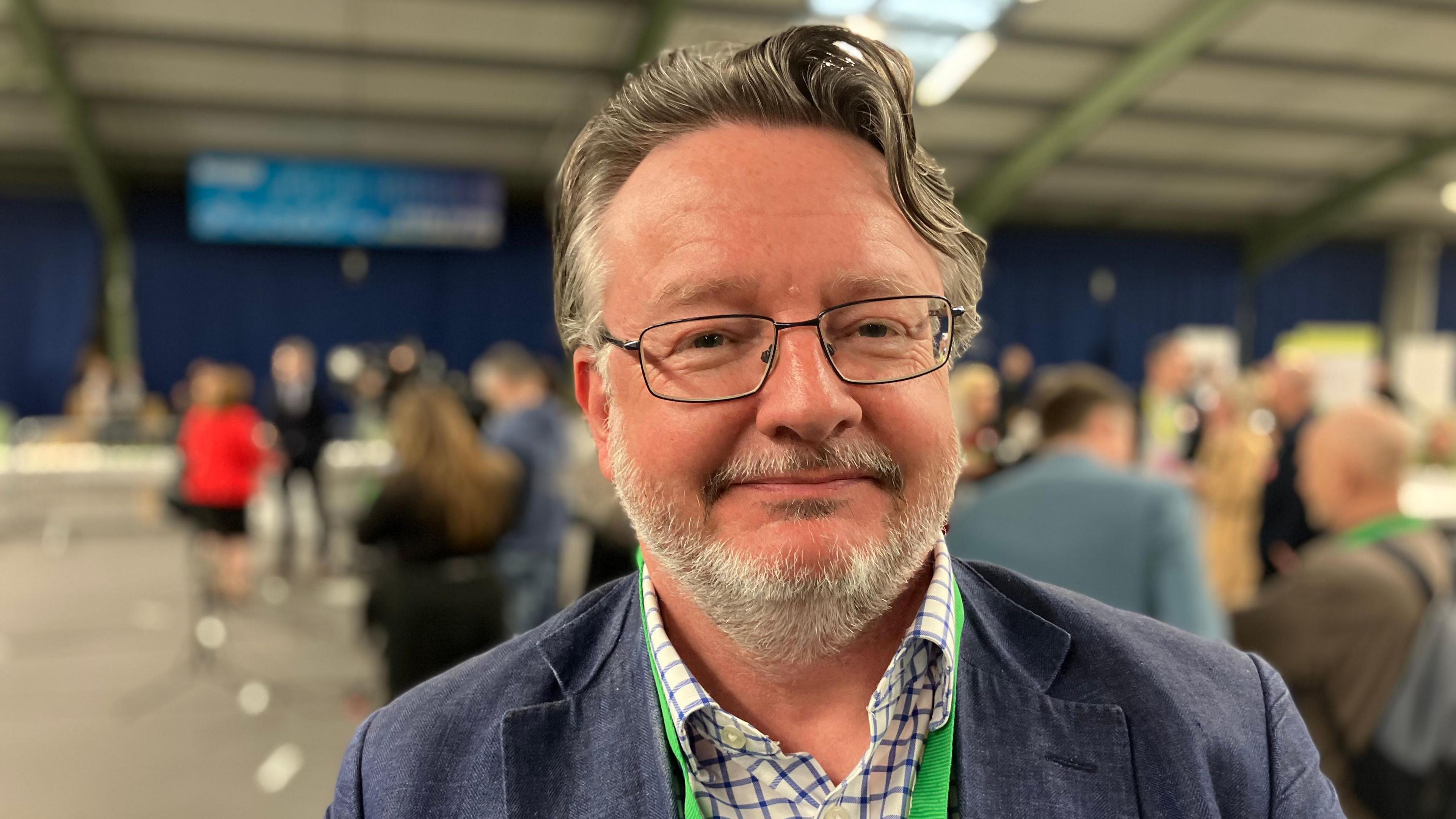 Leader of Derbyshire County Council Barry Lewis, elderly man with grey beard and long grey hair in white and blue chequered shirt and blue jacket 