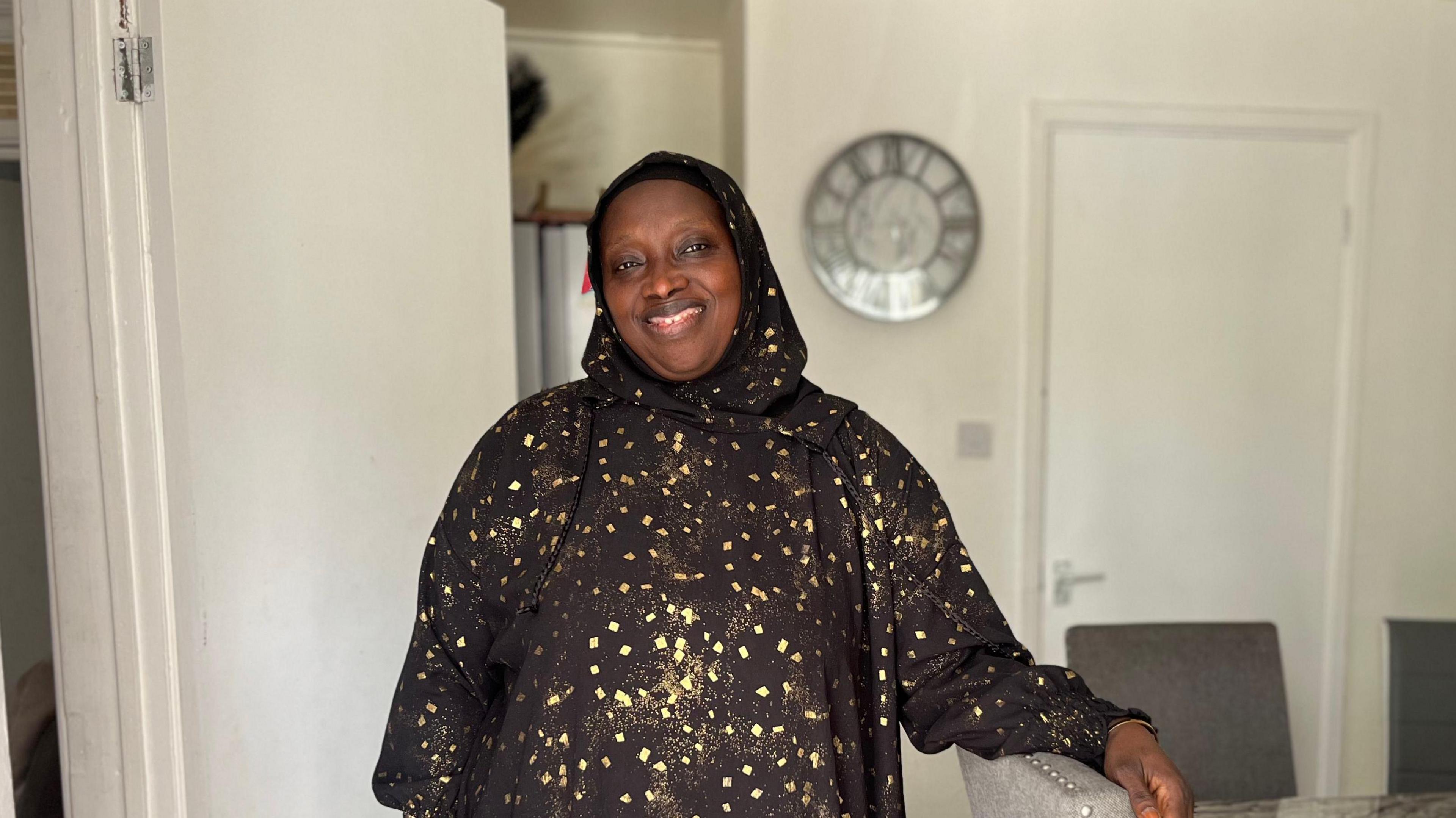 Suwaidu Sanyang smiles for a picture in her living room