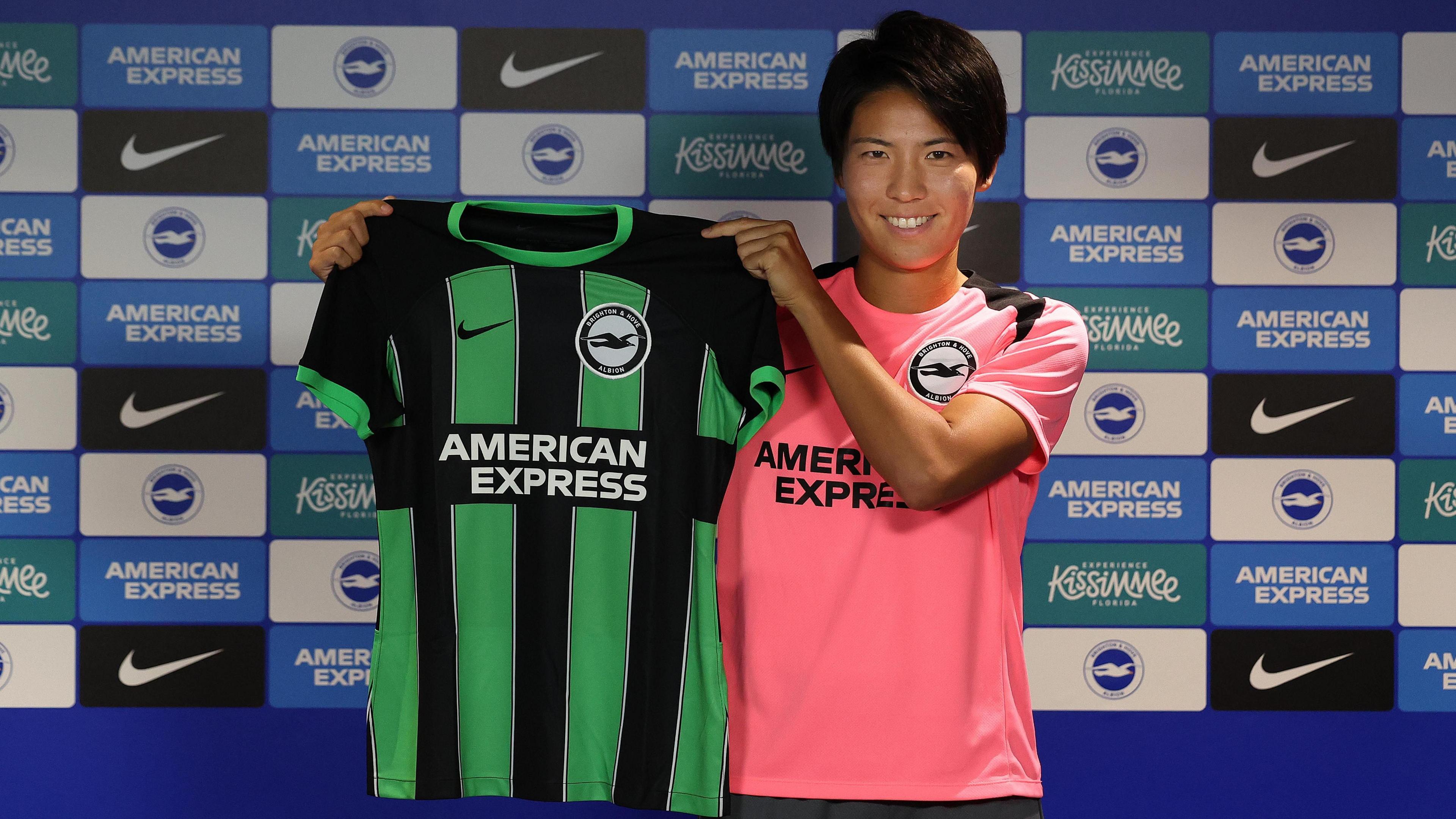 Japan striker Kiko Seike holds up a Brighton shirt at her unveiling