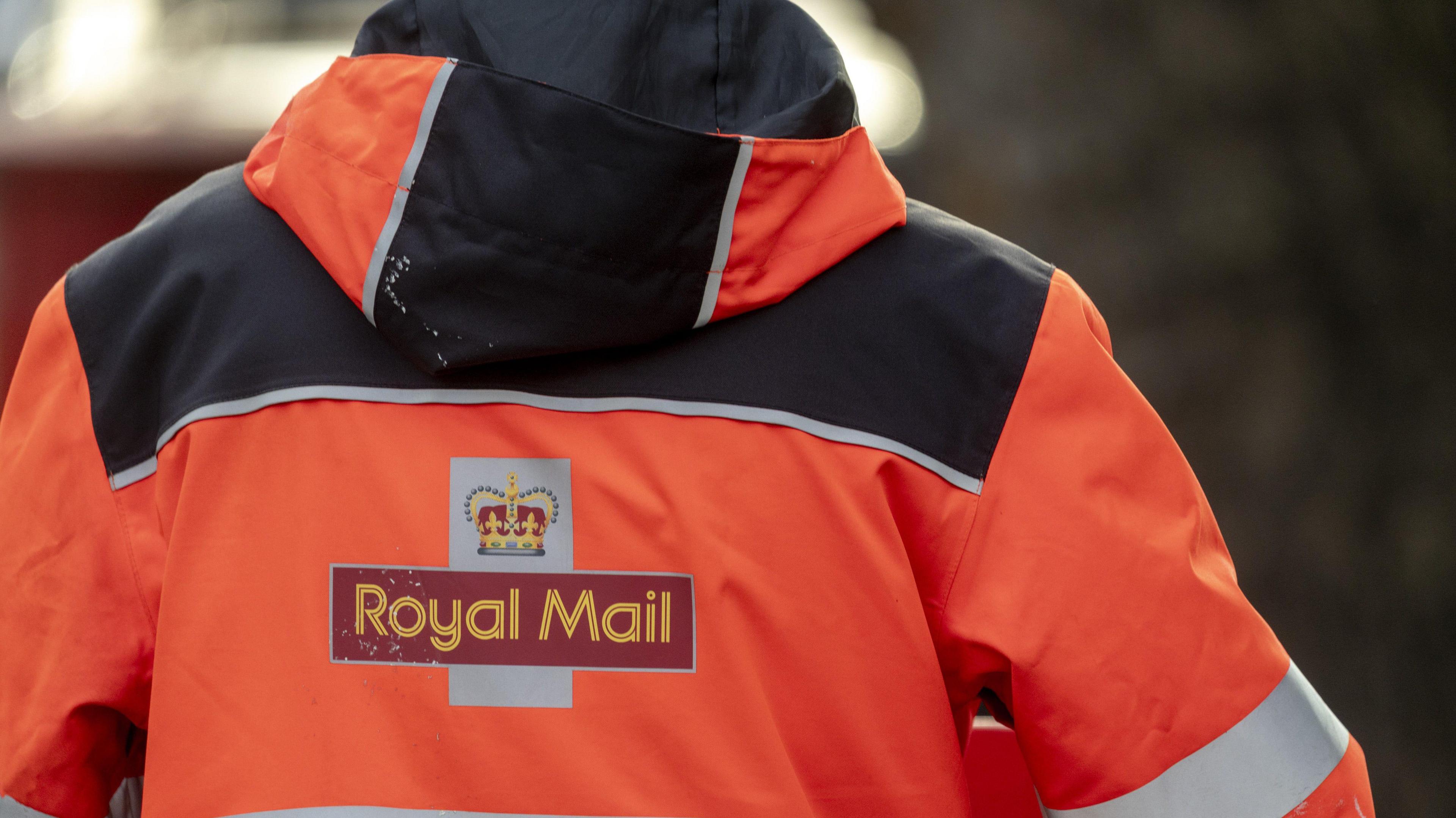 The back of a postal worker's uniform - a luminous orange jacket with 'Royal Mail' emblazoned across it