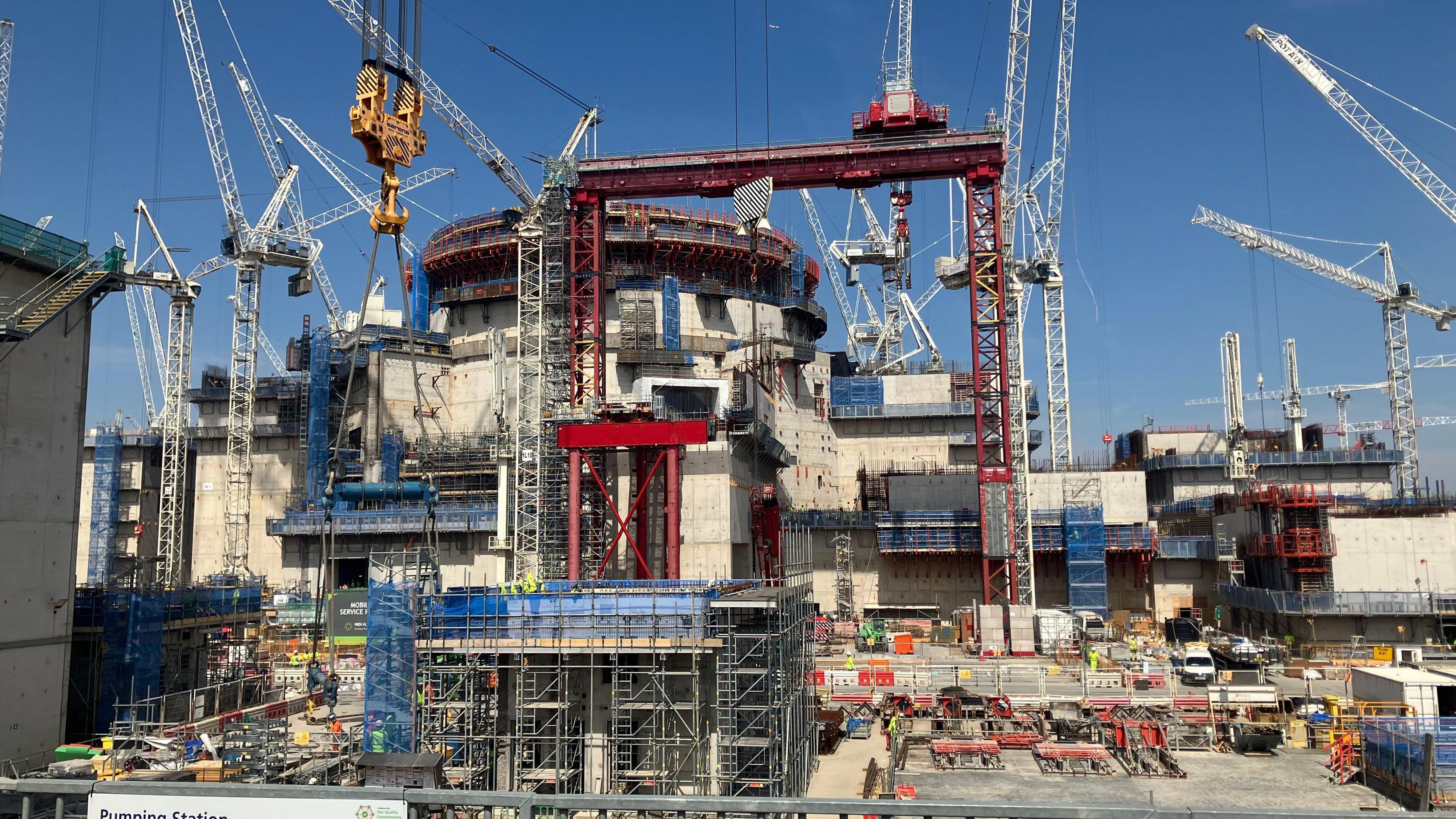 Cranes surround one of the cylindrical reactor buildings at Hinkley Point C