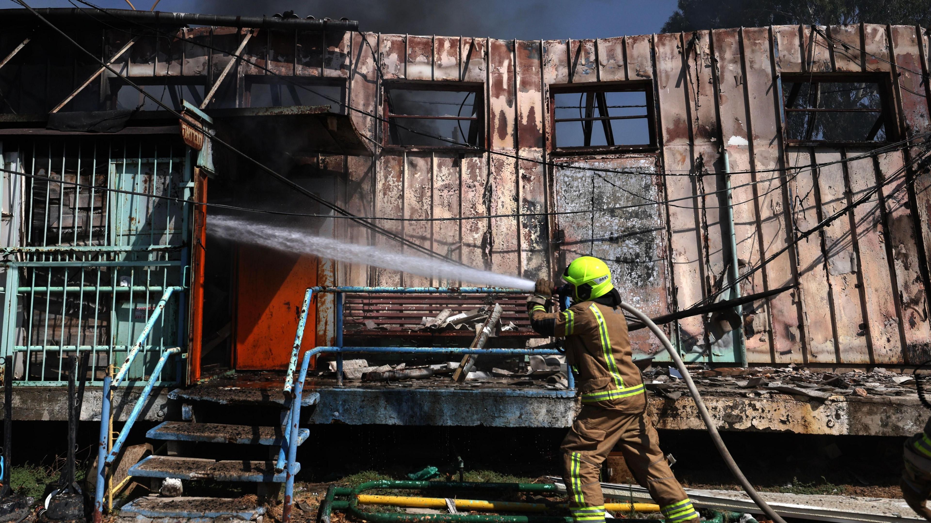 A firefighter tackles a blaze caused by a Hezbollah rocket at an emergency storage facility in Kiryat Shmona, northern Israel (24 September 2024)