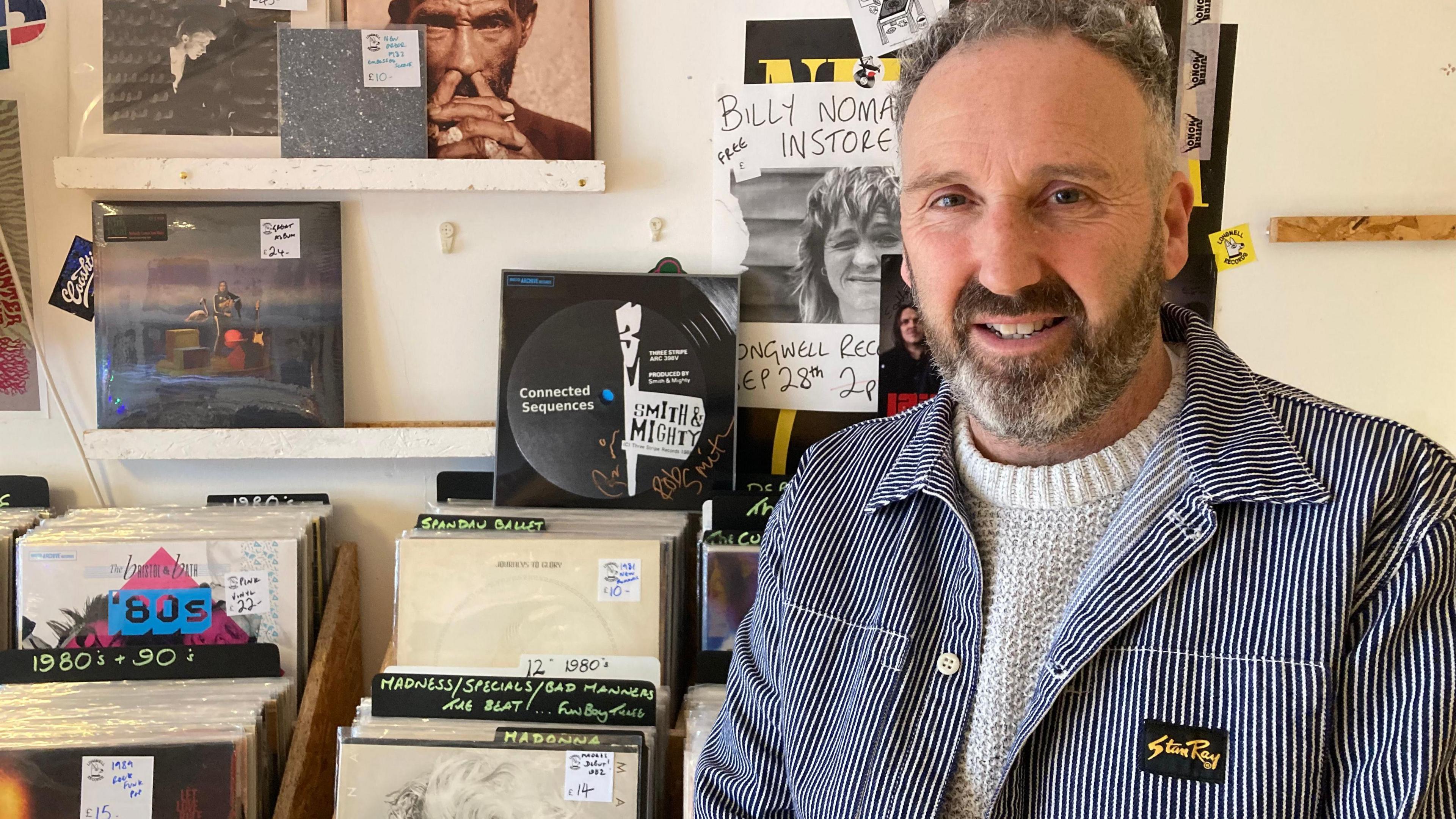 Iain Aitchison standing in front of a collection of vinyls