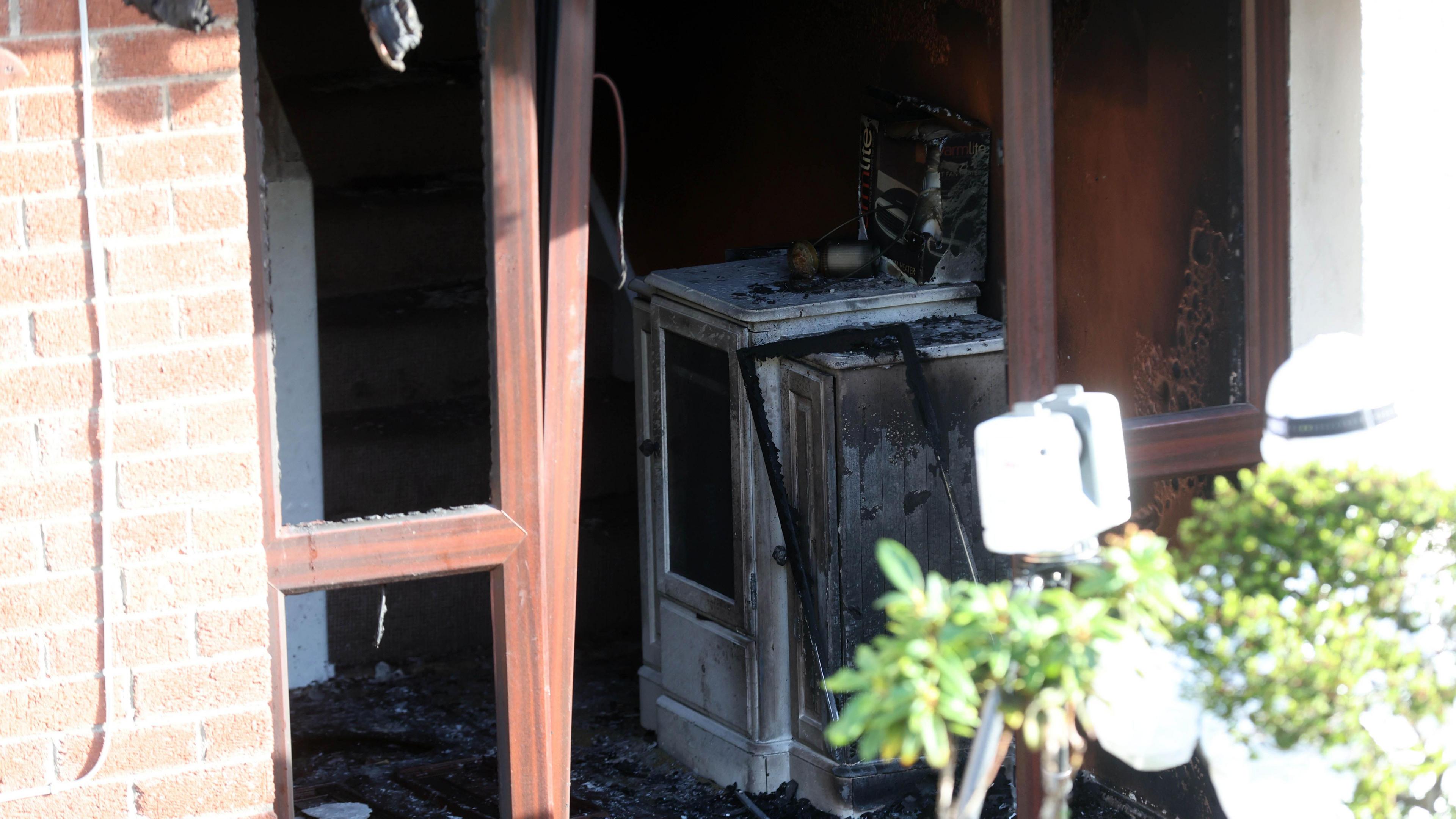 A view of the front door showing a burned hall table. 