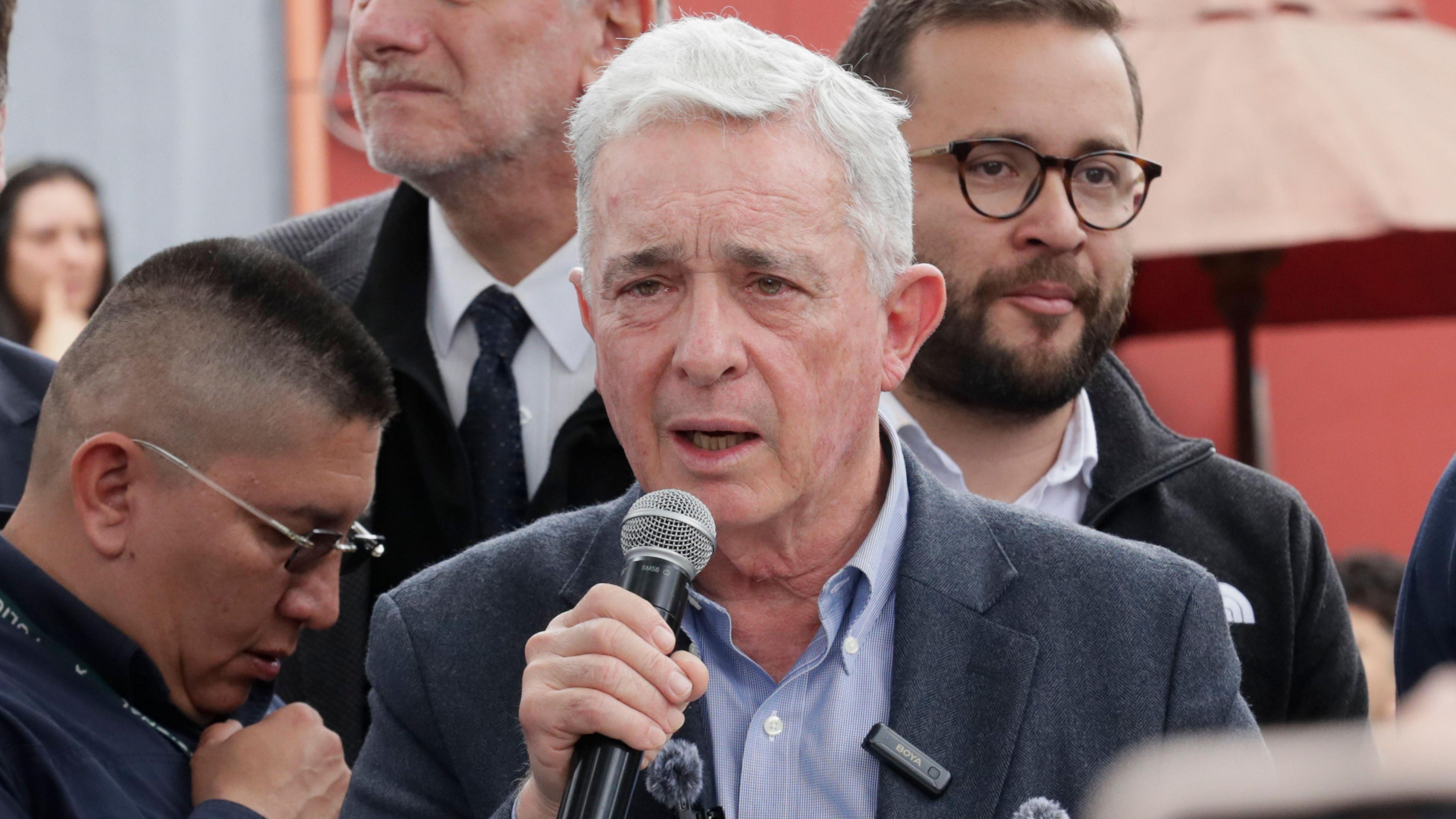 Colombia's former president Alvaro Uribe speaks into a microphone