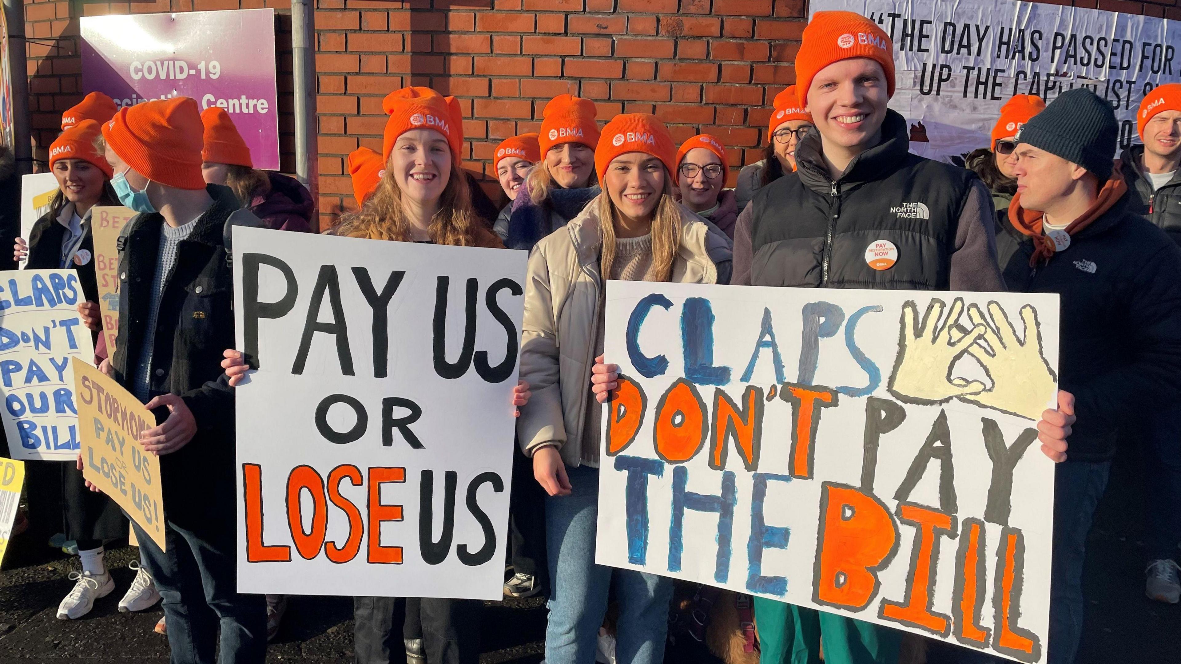 Junior doctors on the picket line at the RVH holding up posts saying 'claps don't pay the bills'