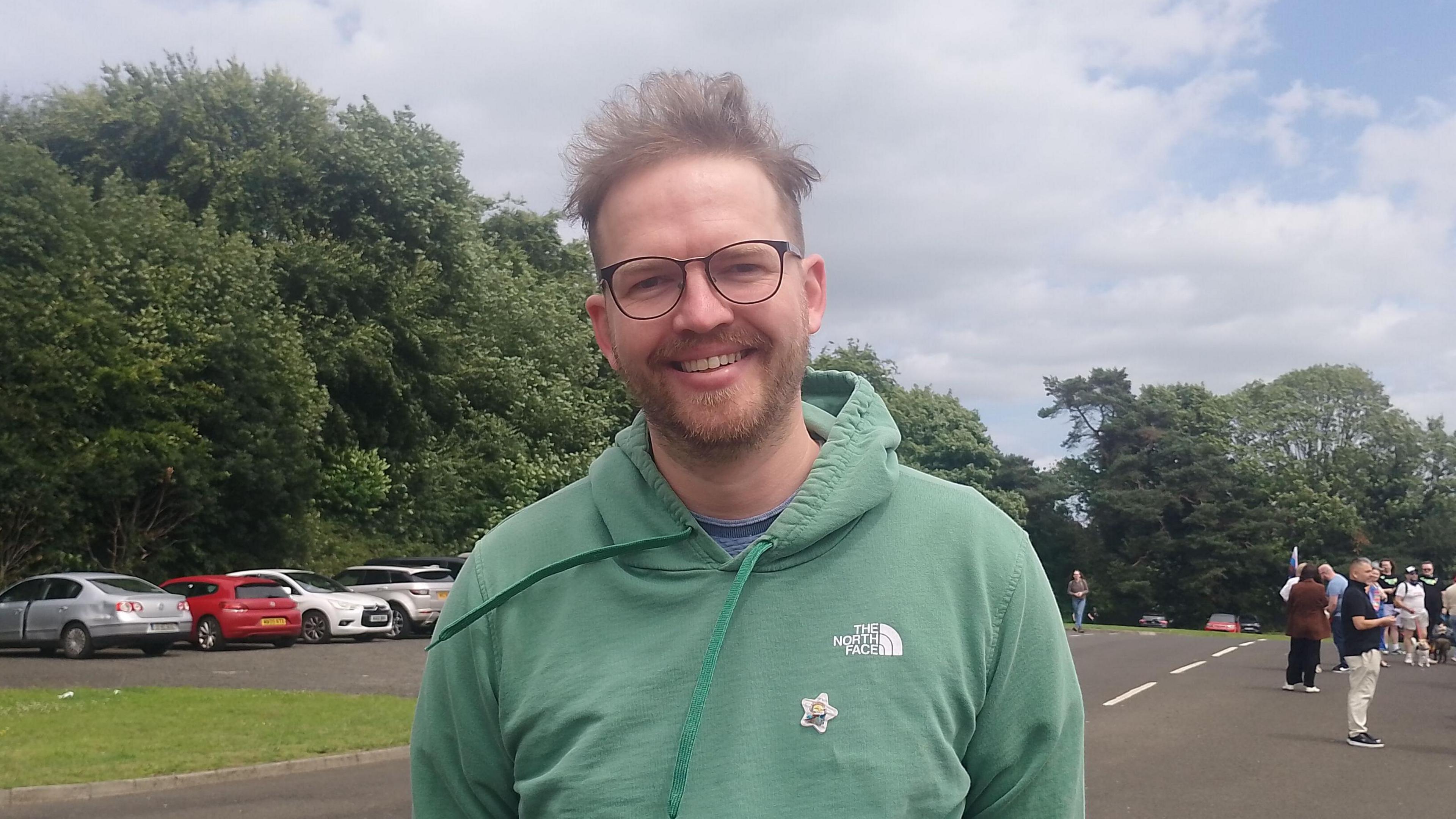 Jack Gibson. He has light brown hair and beard, wearing glasses and a green North Face hoody.