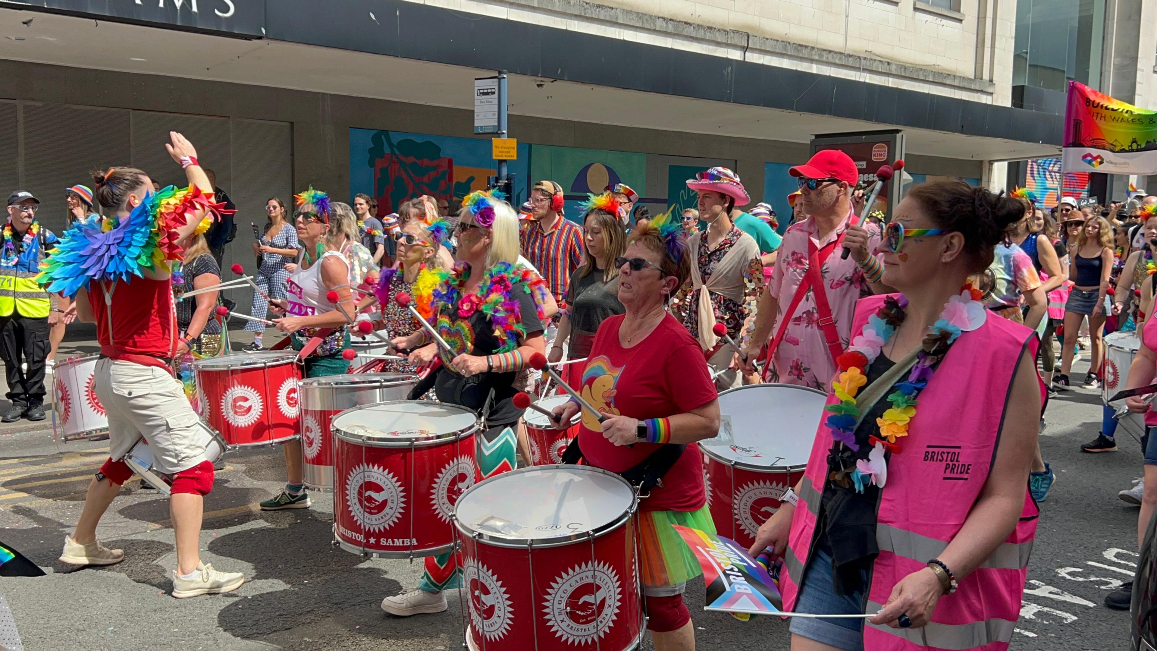 People in rows on the road with drums