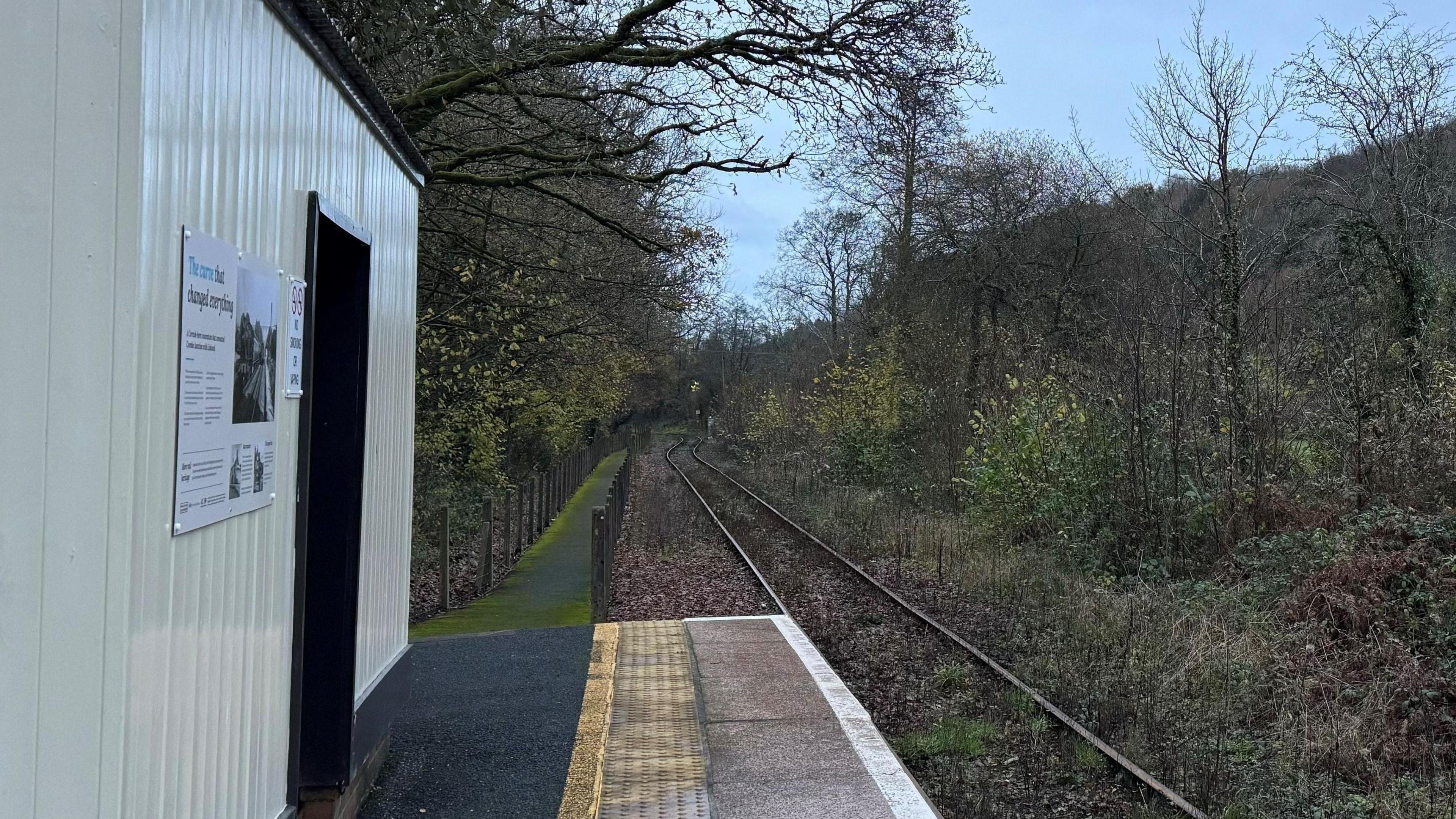 View looking out along railway track with waiting room in the foreground