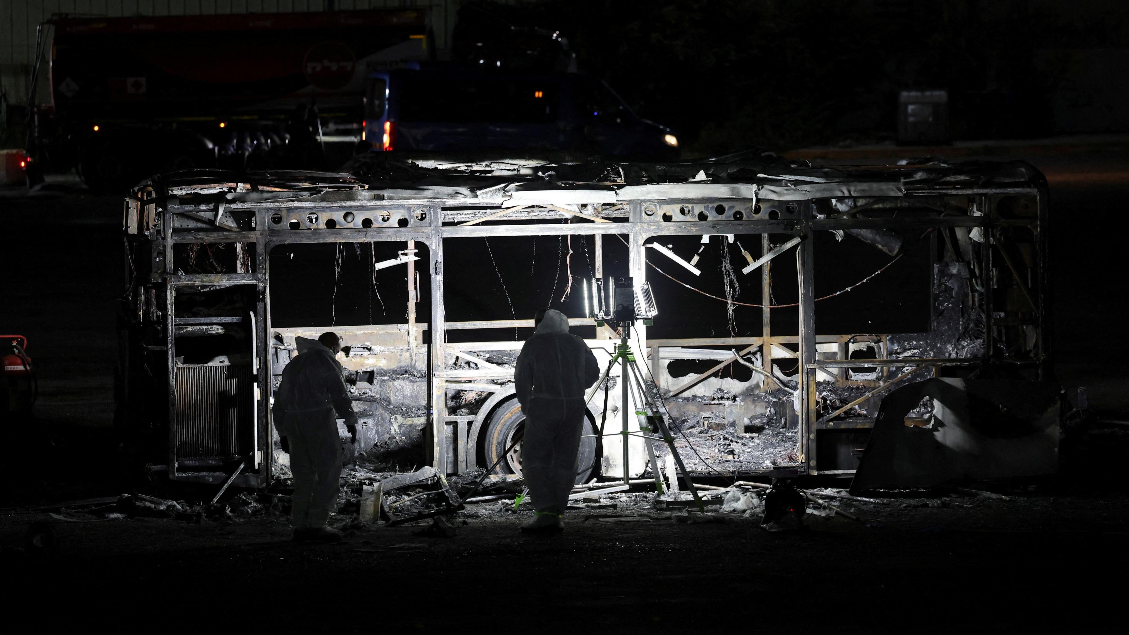 Forensics personnel inspect a bus following its explosion, in Bat Yam, south of Tel Aviv, on Thursday night.