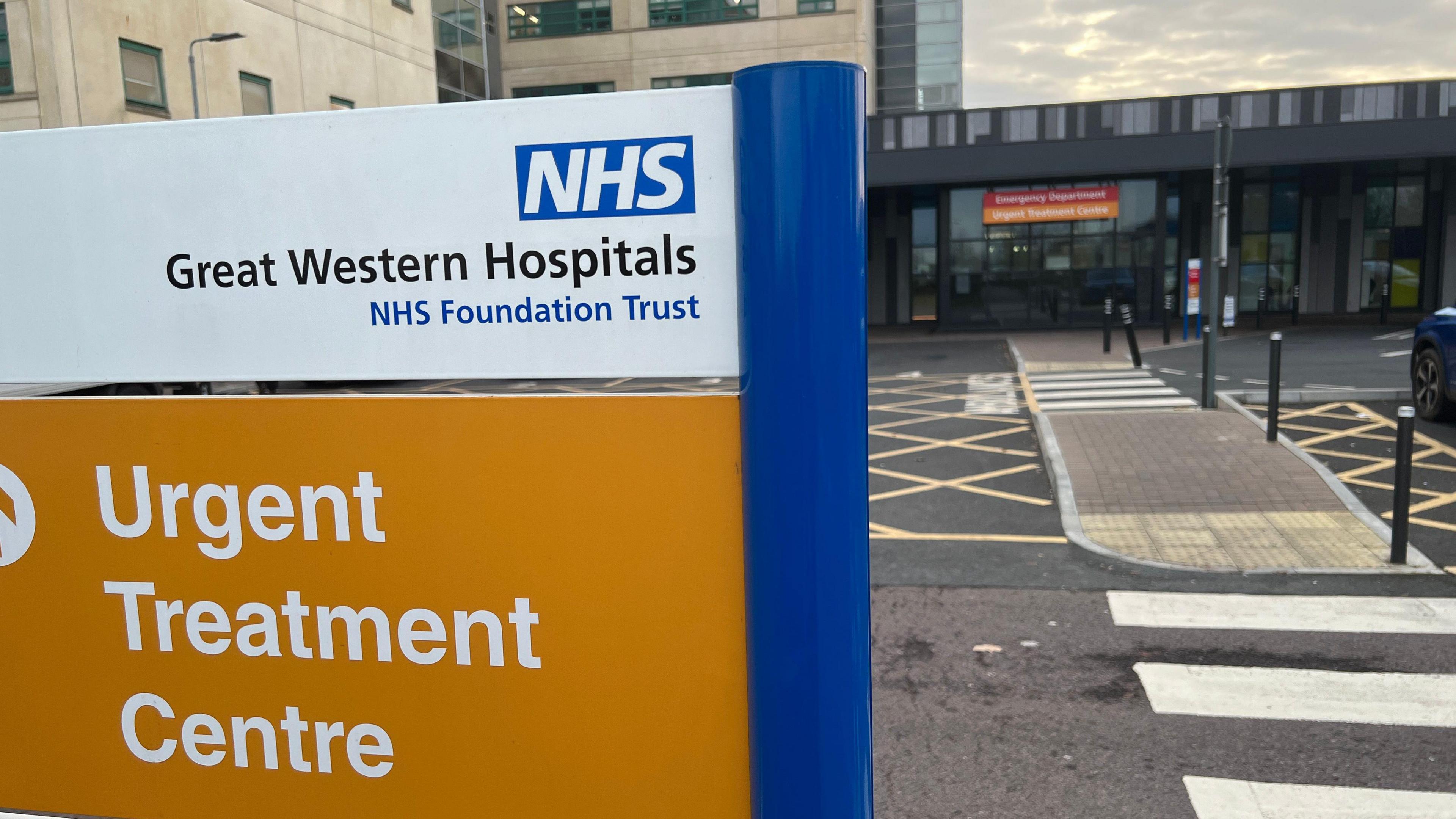 Great Western Hospital orange sign on site in front of building.