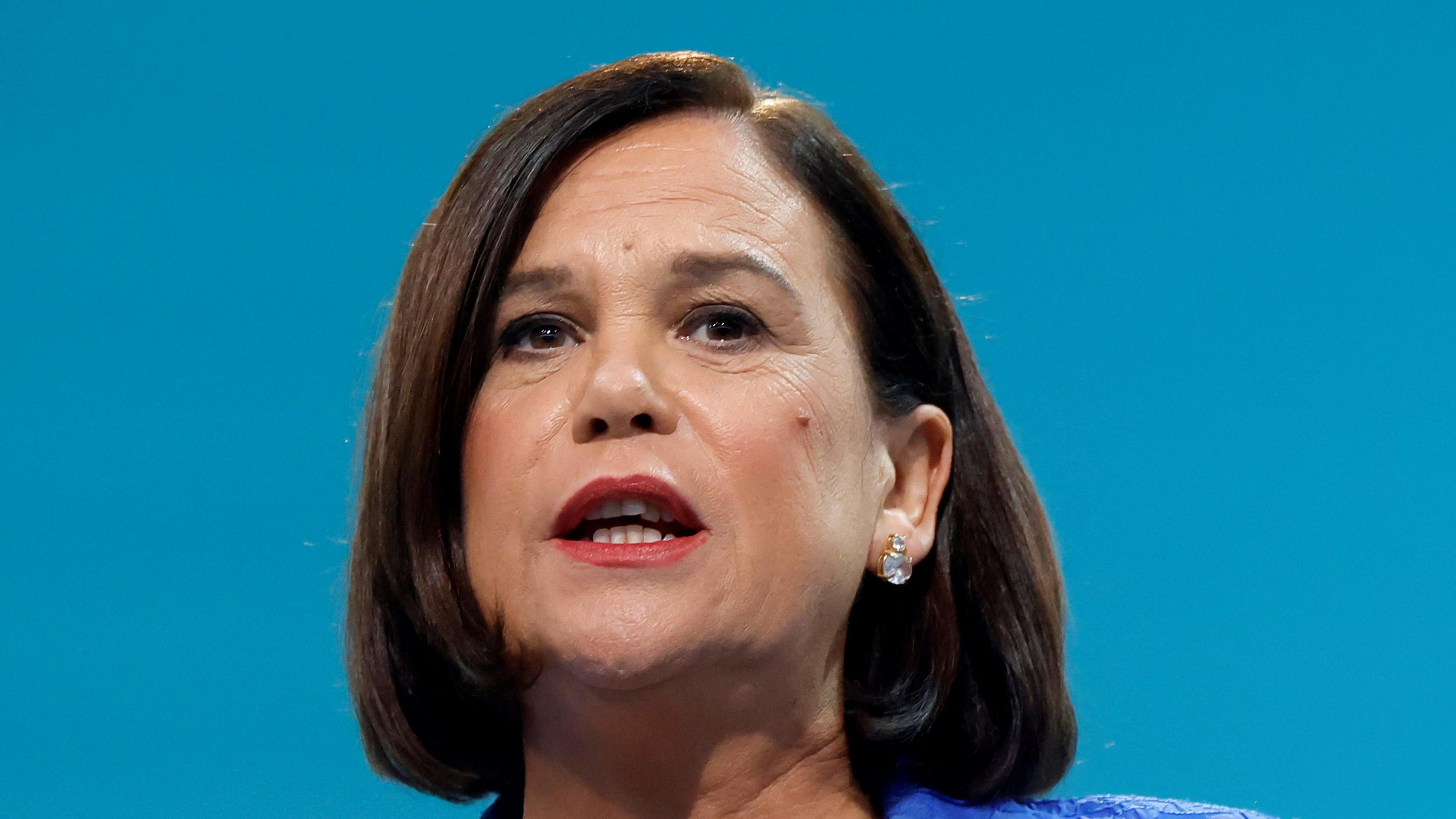 Sinn Fein President Mary Lou McDonald delivers a speech at the Sinn Fein annual party conference in Athlone. She has shoulder length brown hair and brown eyes.