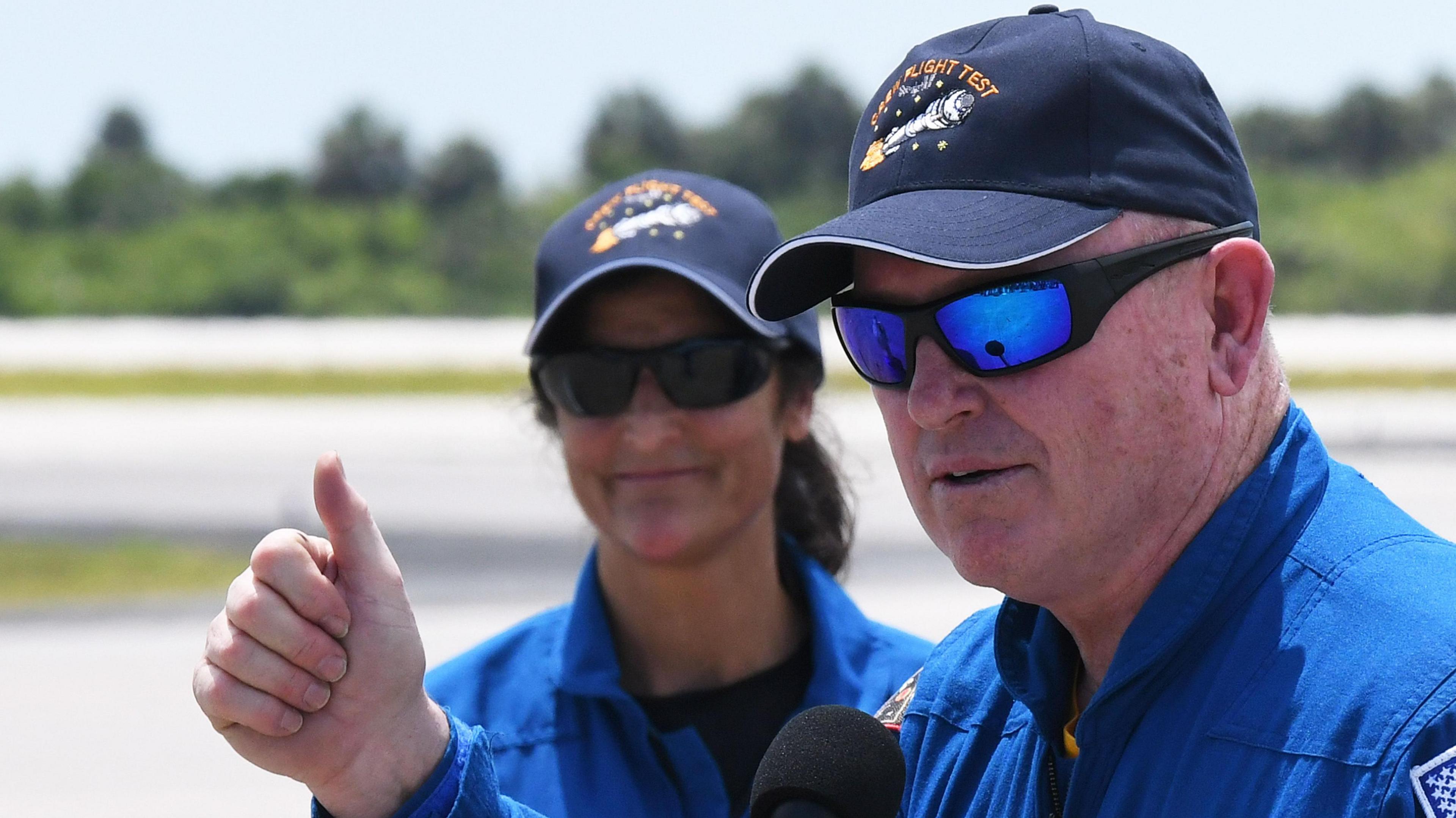 NASA astronaut Butch Wilmore gives a thumbs up as he and astronaut Suni Williams (left), the crew of Boeing's CST-100 Starliner spacecraft, depart after answering questions from the media.