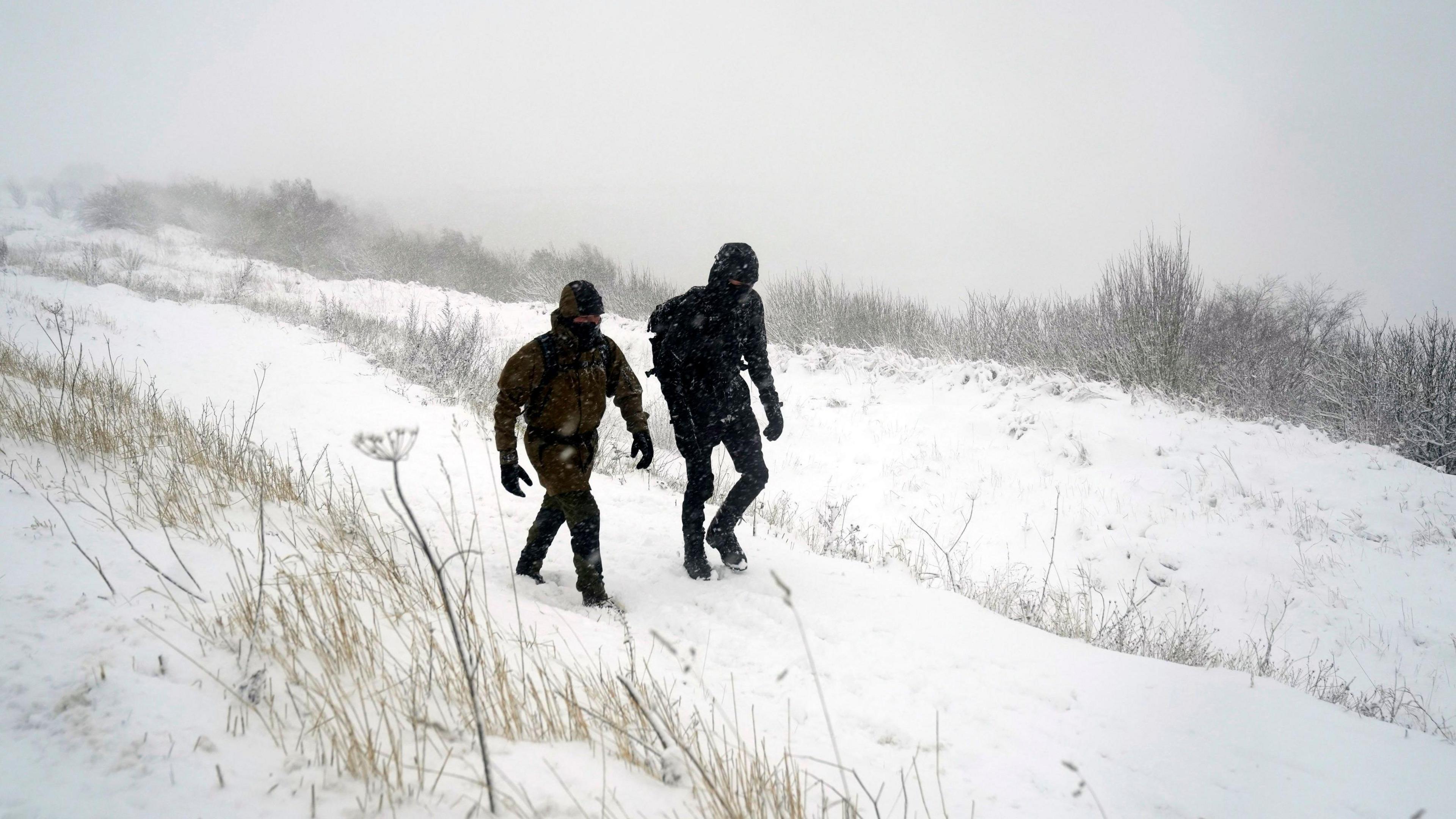 People walking through the snow on the North York Moors.