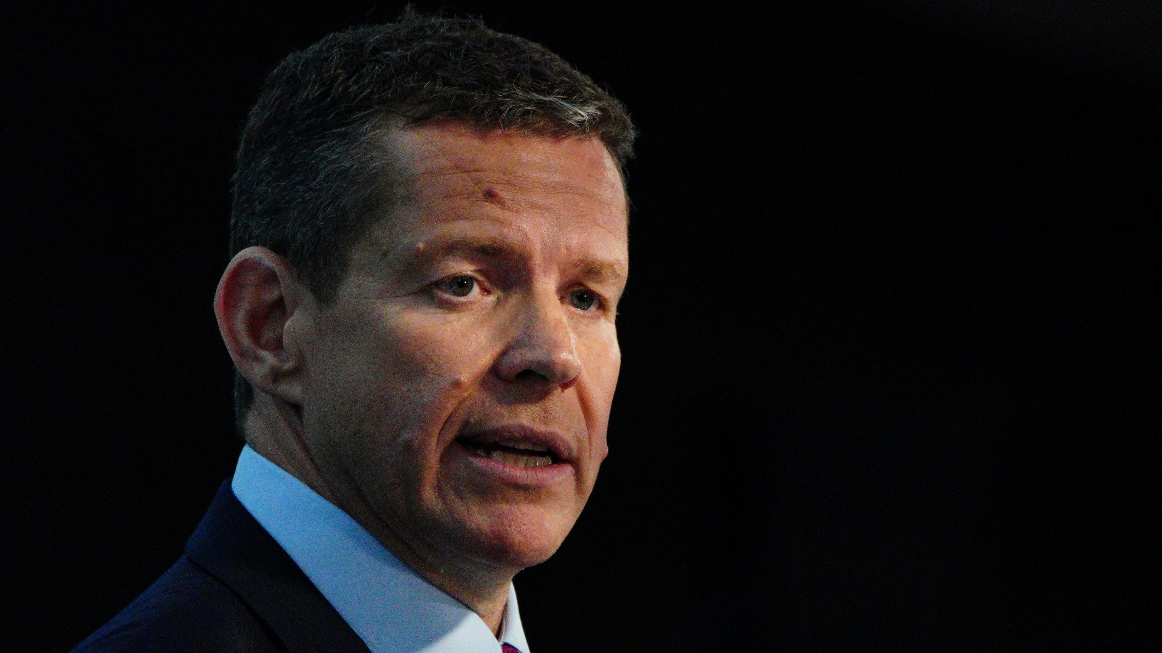 Rhun ap Iorwerth speaking in front of a black backdrop.