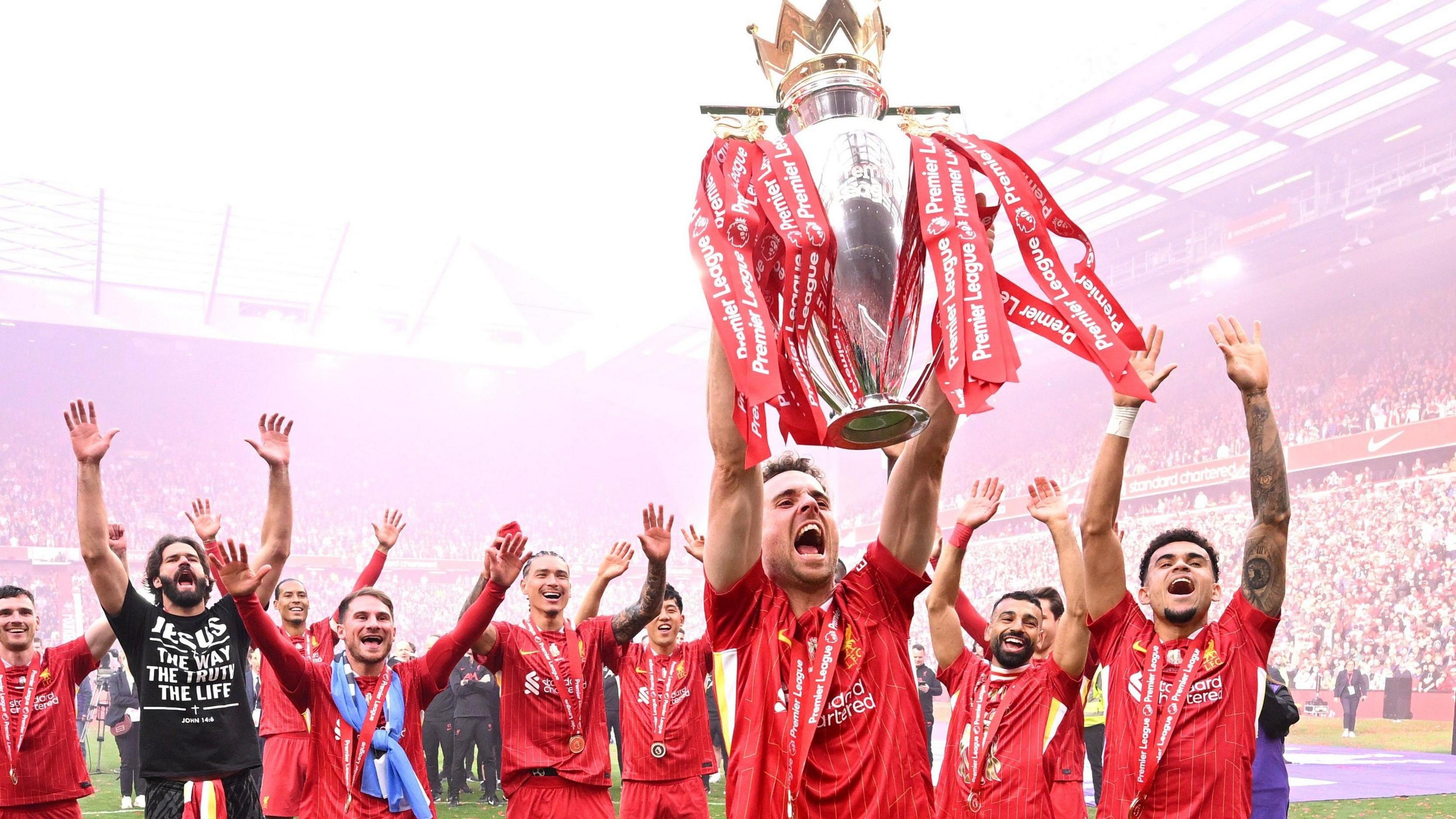 Liverpool's Diogo Jota celebrates with the Premier League trophy in front of The Kop at Anfield