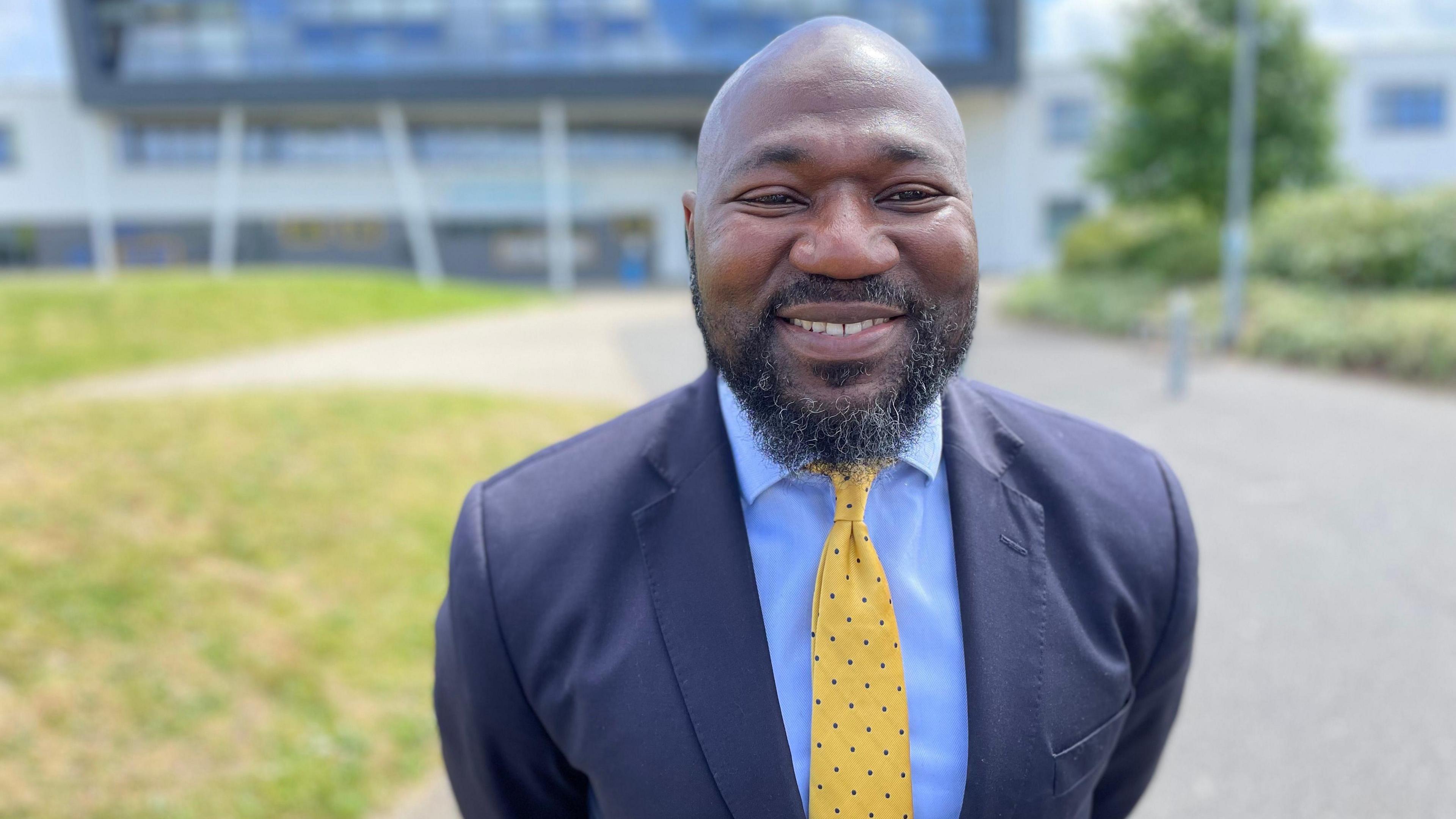 Conservative candidate Festus Akinbusoye in a dark blue suit, light blue shirt and yellow tie